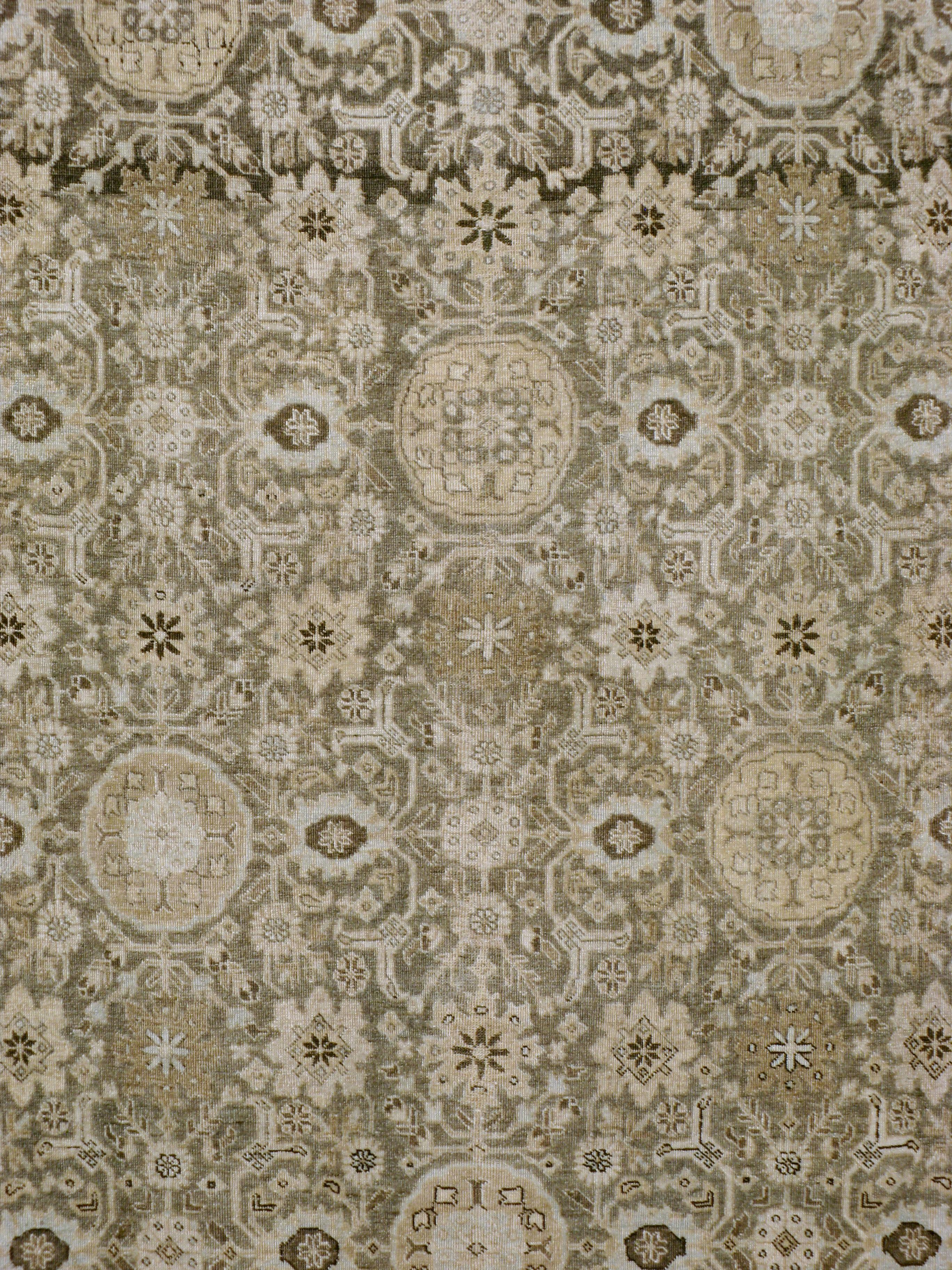 An antique Persian Tabriz room size carpet handmade during the early 20th century in neutral browns and light grey accents.