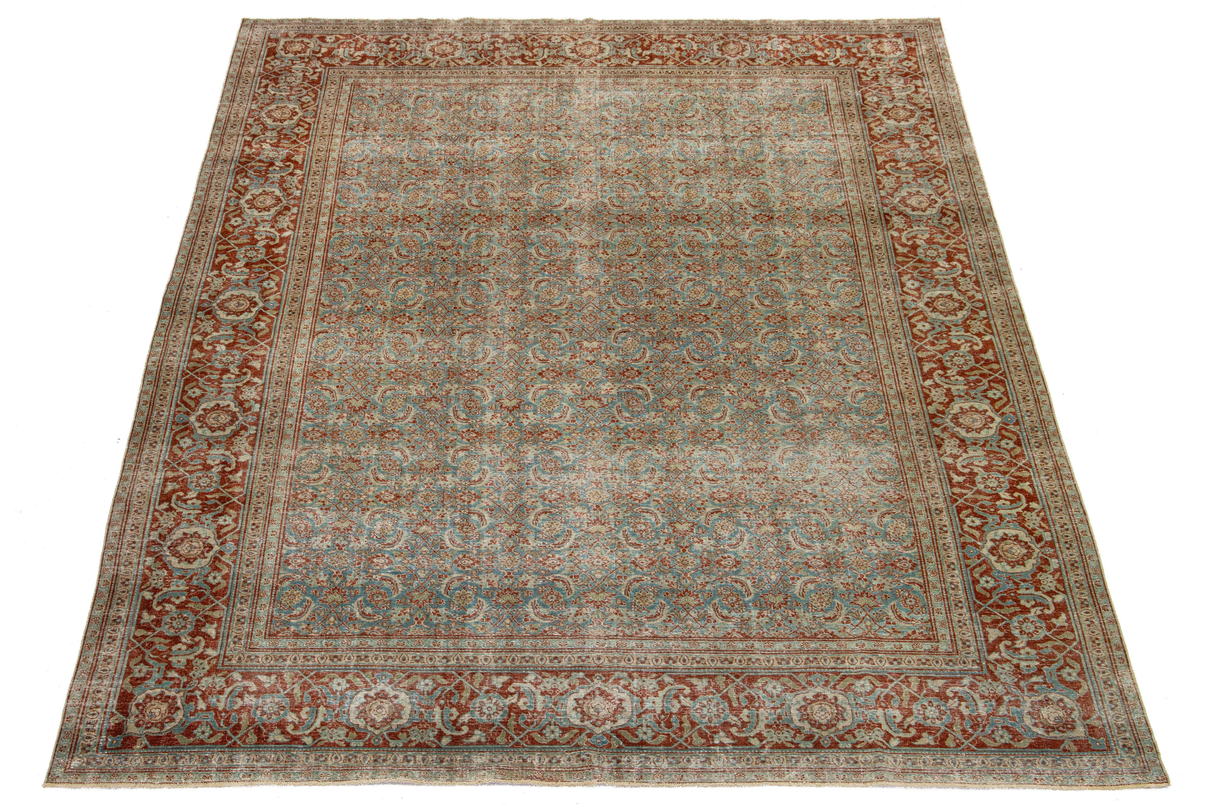 Dieser exquisite antike persische Täbriz-Teppich aus den 1920er Jahren besticht durch ein auffallend blaues Feld mit einem komplizierten Blumenmuster, das durch luxuriöse Akzente in Rost und Beige ergänzt wird. Es ist ein bemerkenswertes Stück, das