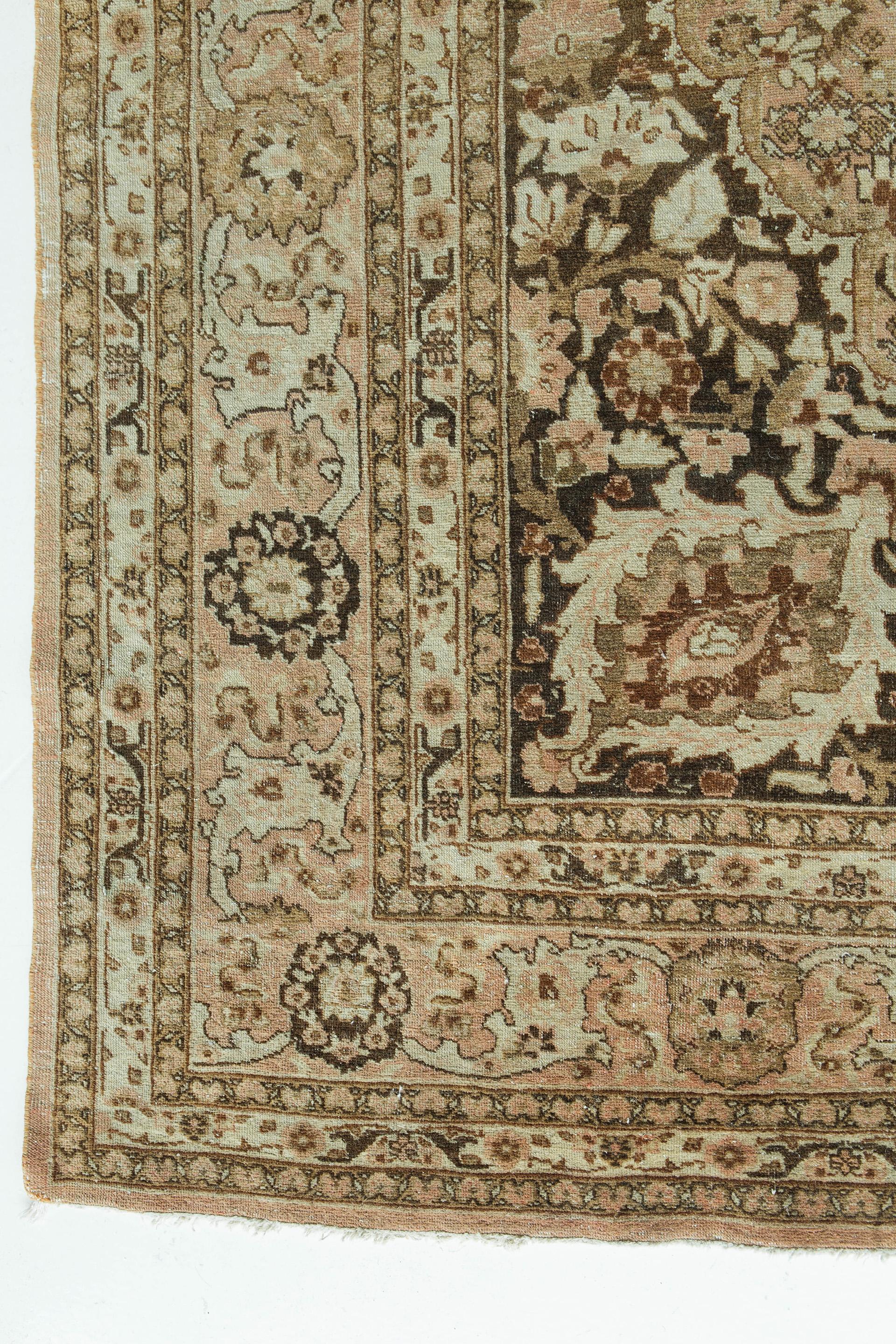 This antique Tabriz in the style of the legendary designer of courtly rugs, Haji Jalili, features a soft brown field with darker brown lobbed medallion and spandrels, and accents of rose, ivory, taupe and burgundy. The densely filled design features