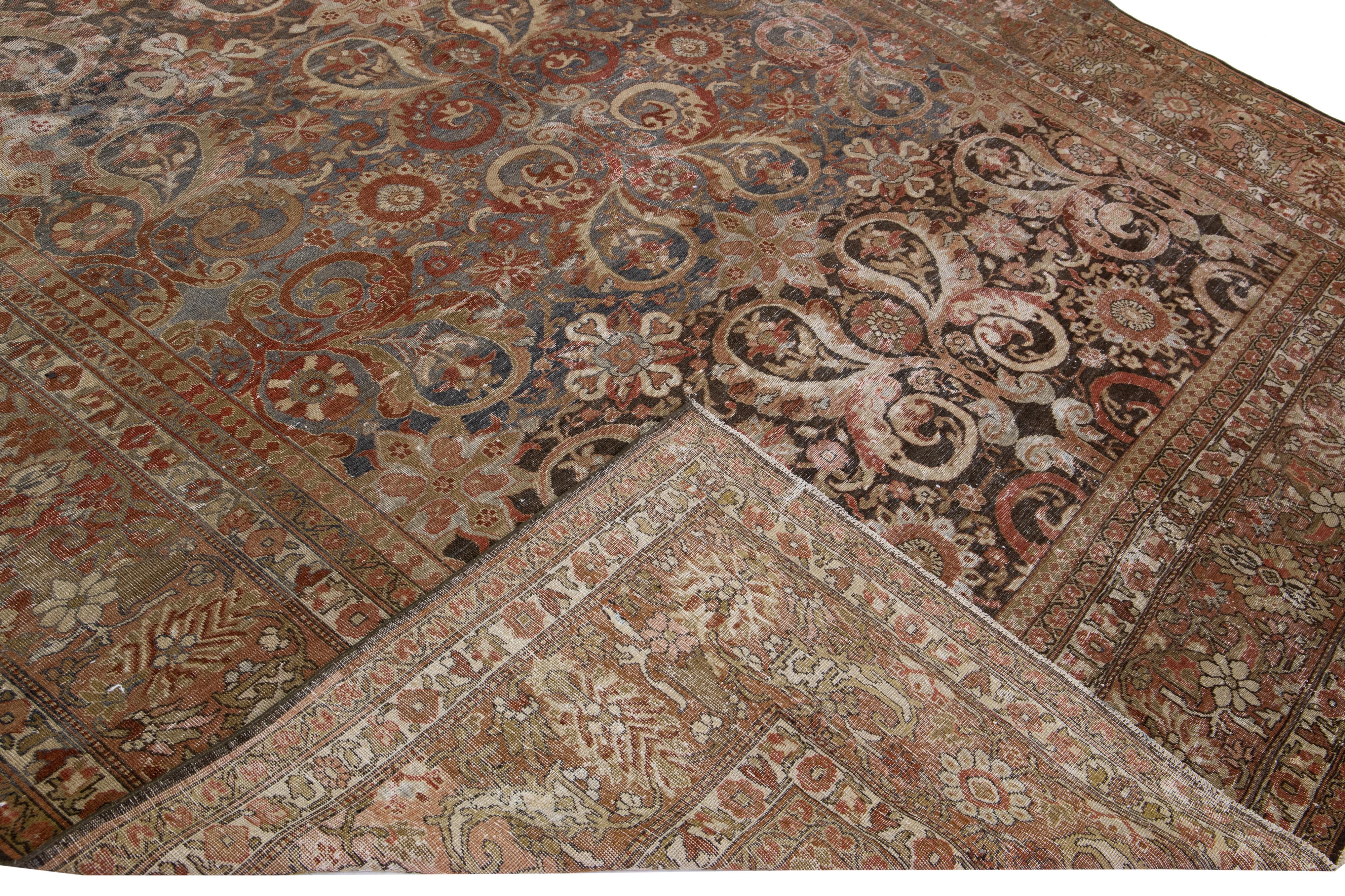 Beautiful antique Tabriz hand-knotted wool rug with a gray and brown field. This Persian piece has a designed frame with an orange-rusted accent color in the traditional all-over design. 

This rug measures: 9'6