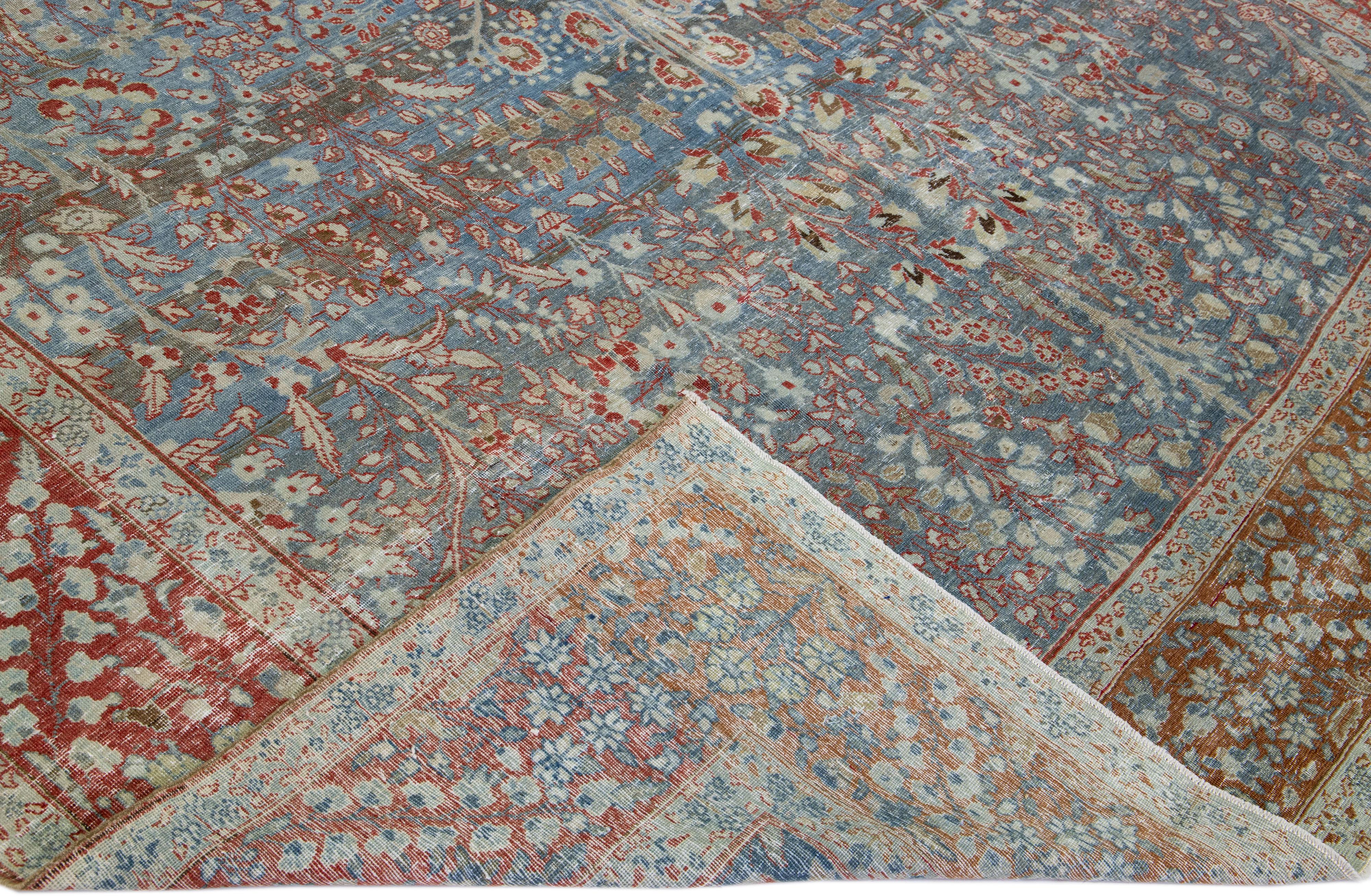 Beautiful antique Tabriz hand-knotted wool rug with a blue color field. This Persian rug has a red frame and accents in a gorgeous all-over floral design.

This rug measures: 9'5