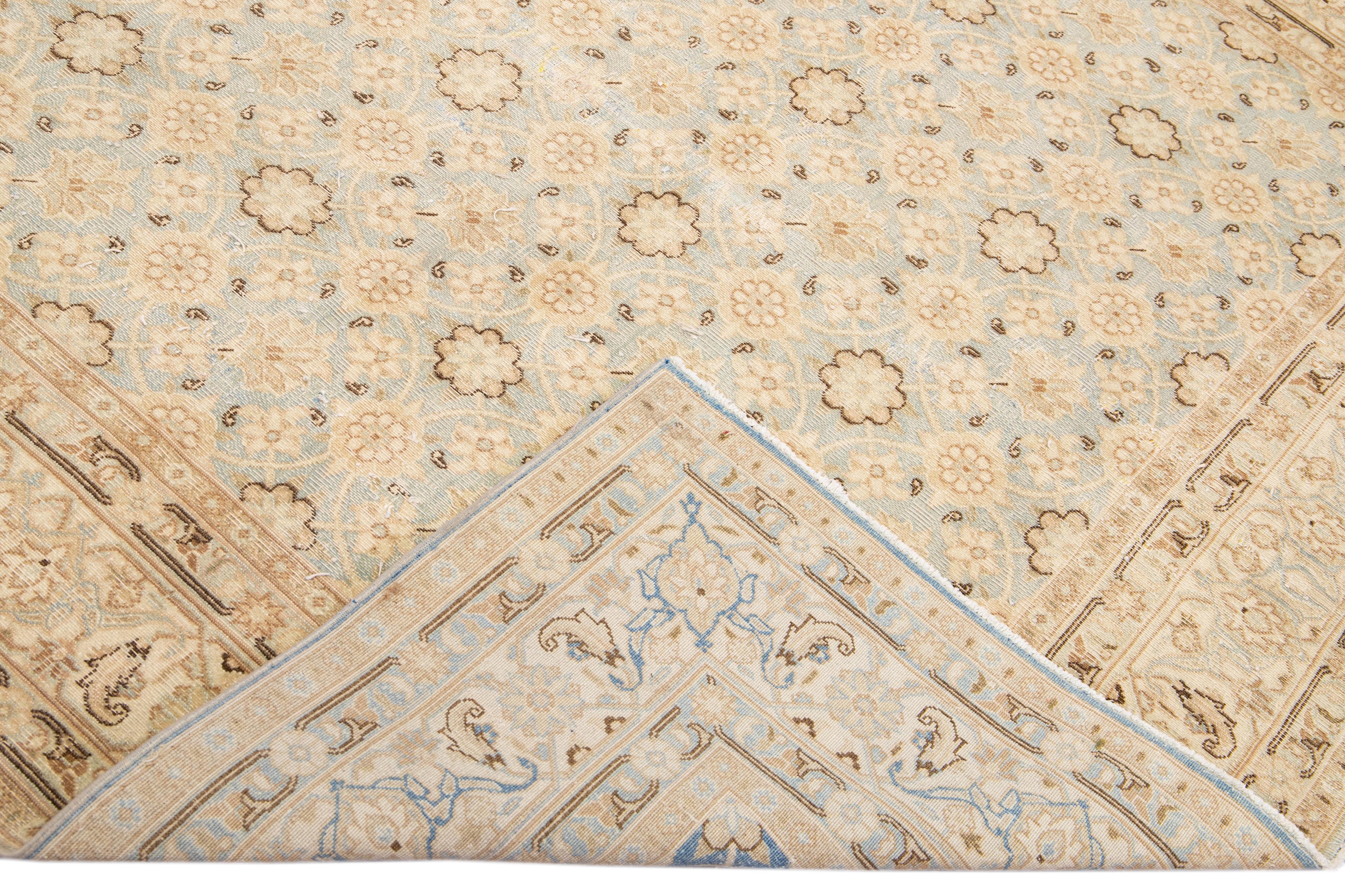 Beautiful antique Persian Tabriz hand-knotted wool rug with a blue field. This piece has a beige accent in an all-over gorgeous floral design.

This rug measures: 6'6
