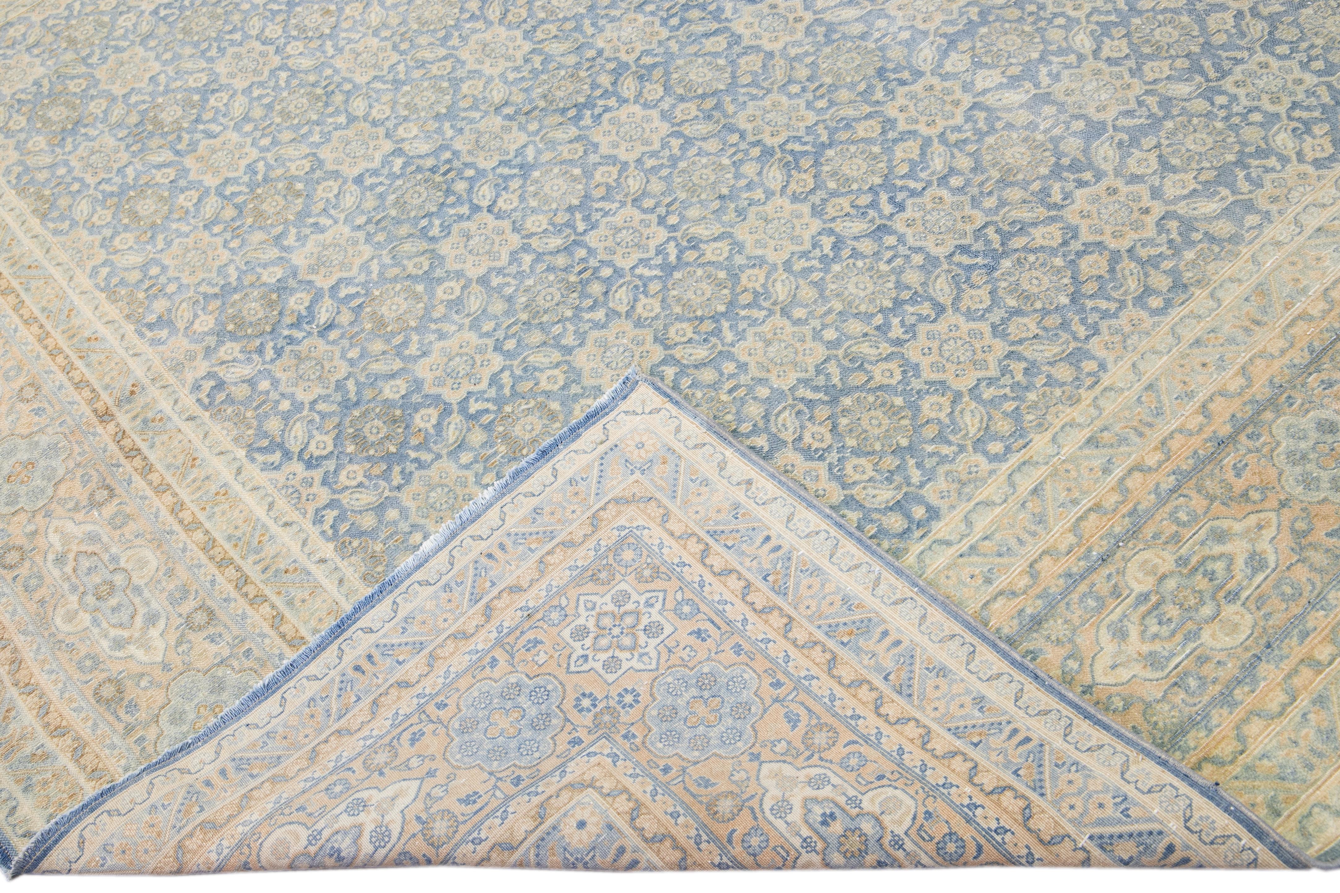 Beautiful antique Persian Tabriz hand-knotted wool rug with a blue field. This piece has a beige frame and accent in an all-over gorgeous floral design.

This rug measures: 8'8
