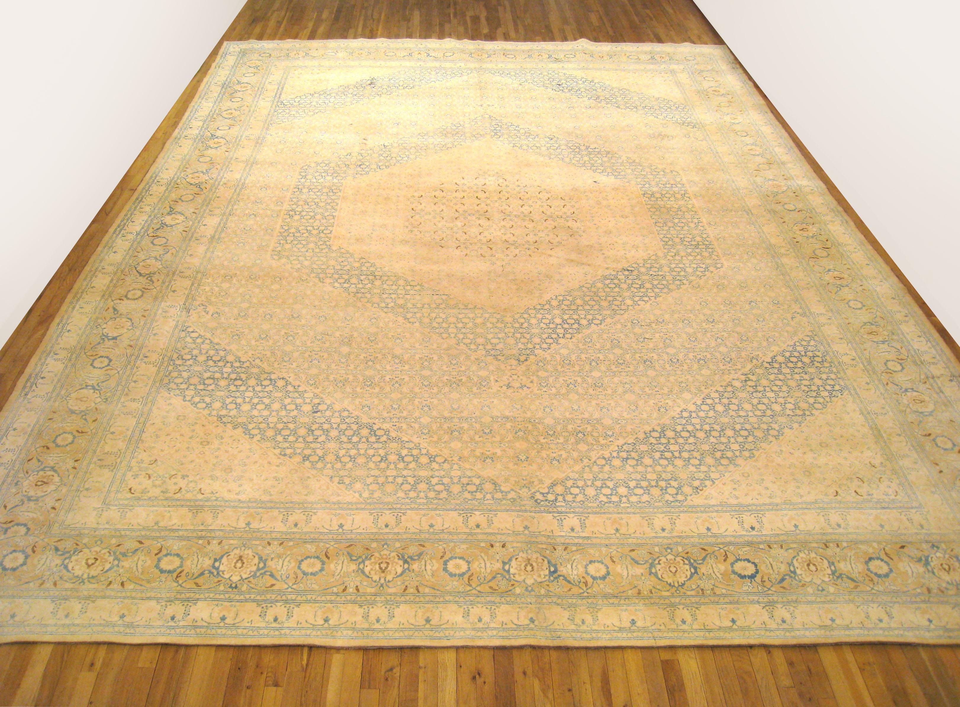 An antique Persian Tabriz oriental carpet, circa 1900, hand knotted with wool in the Tabriz region of Persia. The central field is characterized by a series of expanding medallions, as well as a repeating Herati design throughout. Soft colors.