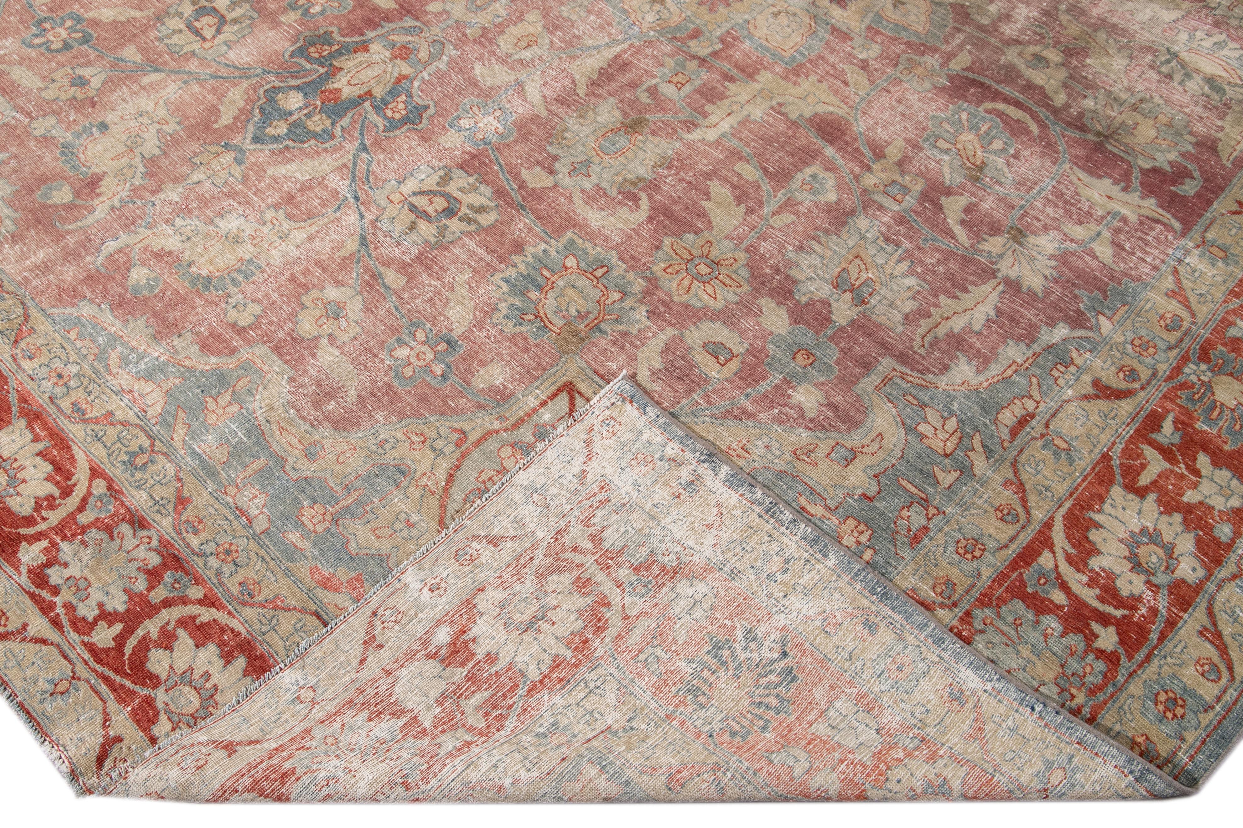 Beautiful antique Persian Tabriz hand-knotted wool rug with a red and blue field. This Tabriz has a rusted frame and multi-color accents in a gorgeous all-over center-medallion floral distressed design.

This rug measures: 11'3