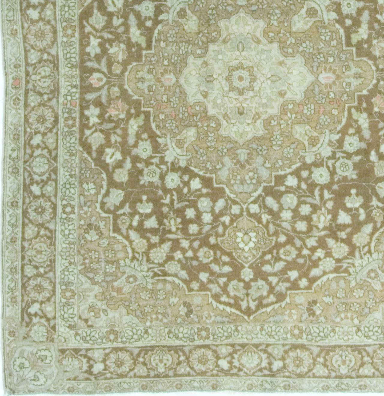 Antique Persian Tabriz rug carpet, circa 1900.The central medallion has wonderful floral details and is then enclosed in a larger medallion. The color combination of soft ivory and browns and slightly deeper shades gives a wonderful look and
