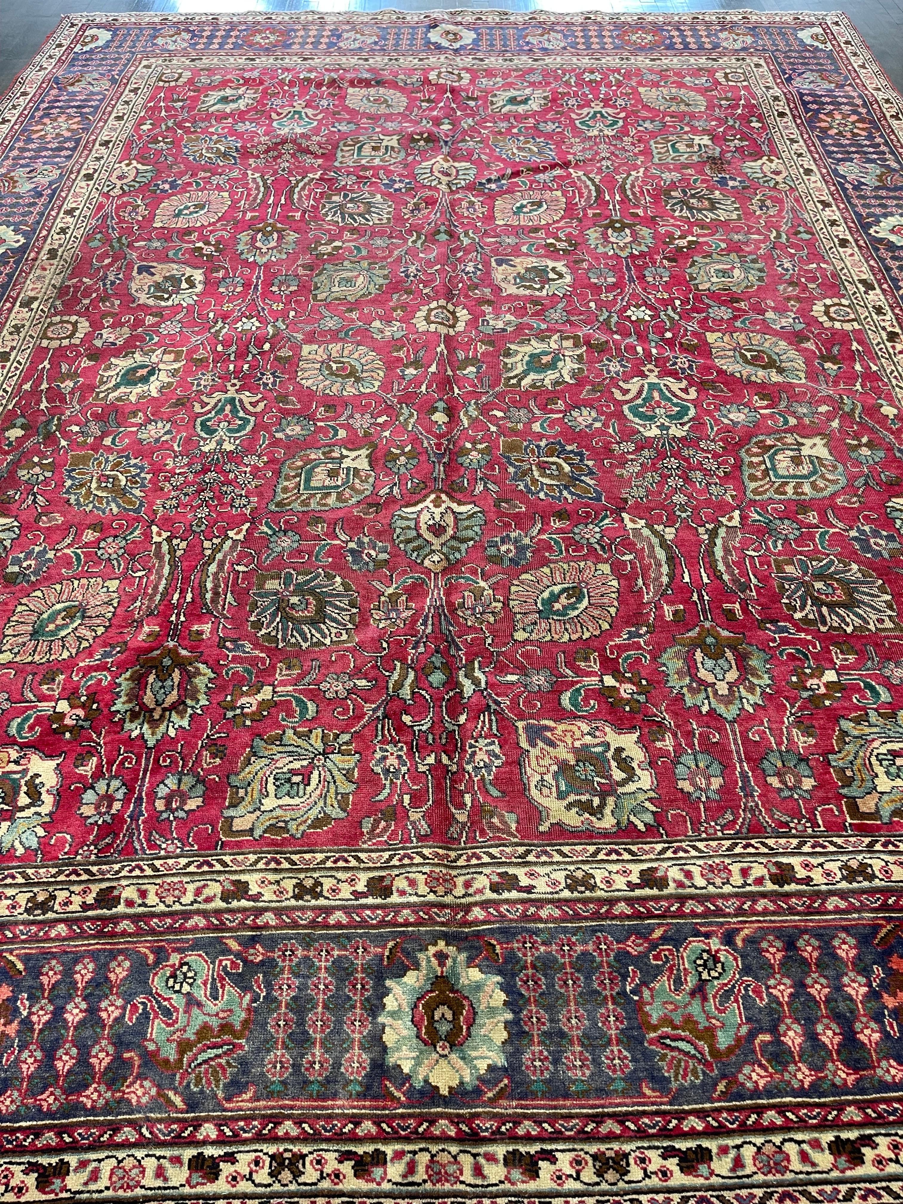 Authentic antique Persian Tabriz in a rare magenta (purplish-red) field with an angular all-over trellis of floral sprays framed on a navy blue border. This distressed rug would work with various interiors like rustic, tudor, arts and crafts or