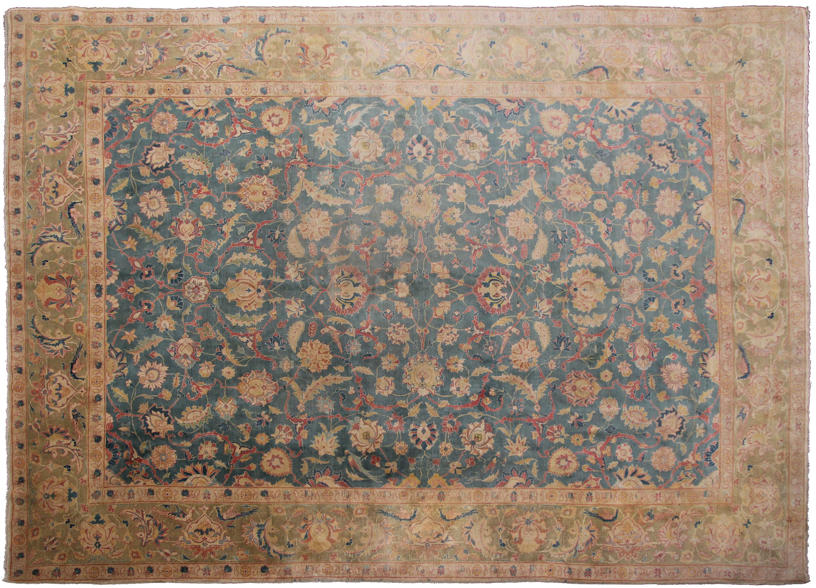 Questo antico tappeto Tabriz, risalente al 1920 circa, presenta una trama splendidamente dettagliata e un'elegante tavolozza a fondo blu arricchita da morbidi elementi floreali e geometrici. La sua colorazione armoniosa, la lana pregiata e la