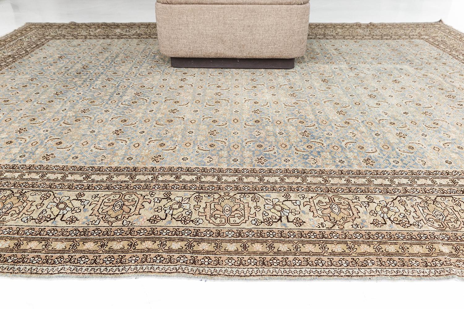 Un Tabriz persan ancien à la fois unique et élégant. En plus de sa qualité supérieure, ce Tabriz présente un champ bleu antique parfait et est orné de volutes florales et de vignobles en or, beige et ivoire. Tabriz, dans le nord-ouest de l'Iran, est
