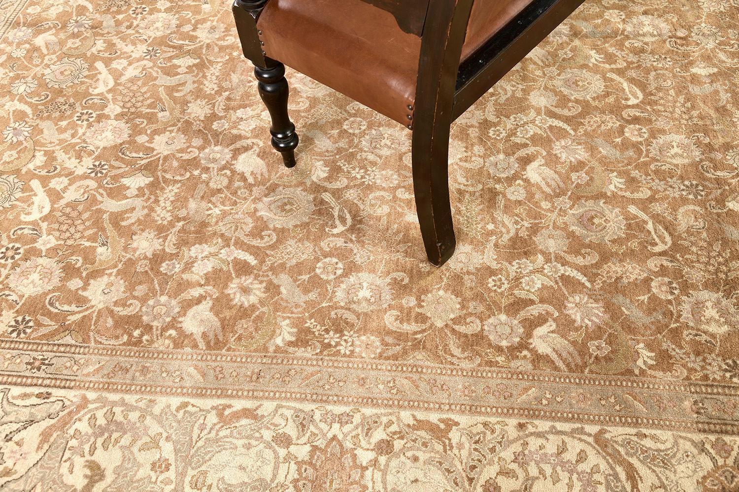 True to the best antique Persian Tabriz rugs, this beautiful Persian rug displays an incredible amount of detail using a relatively limited color palette. Several beige and brown colors dominate the masterpiece’s surface, standing out against cream
