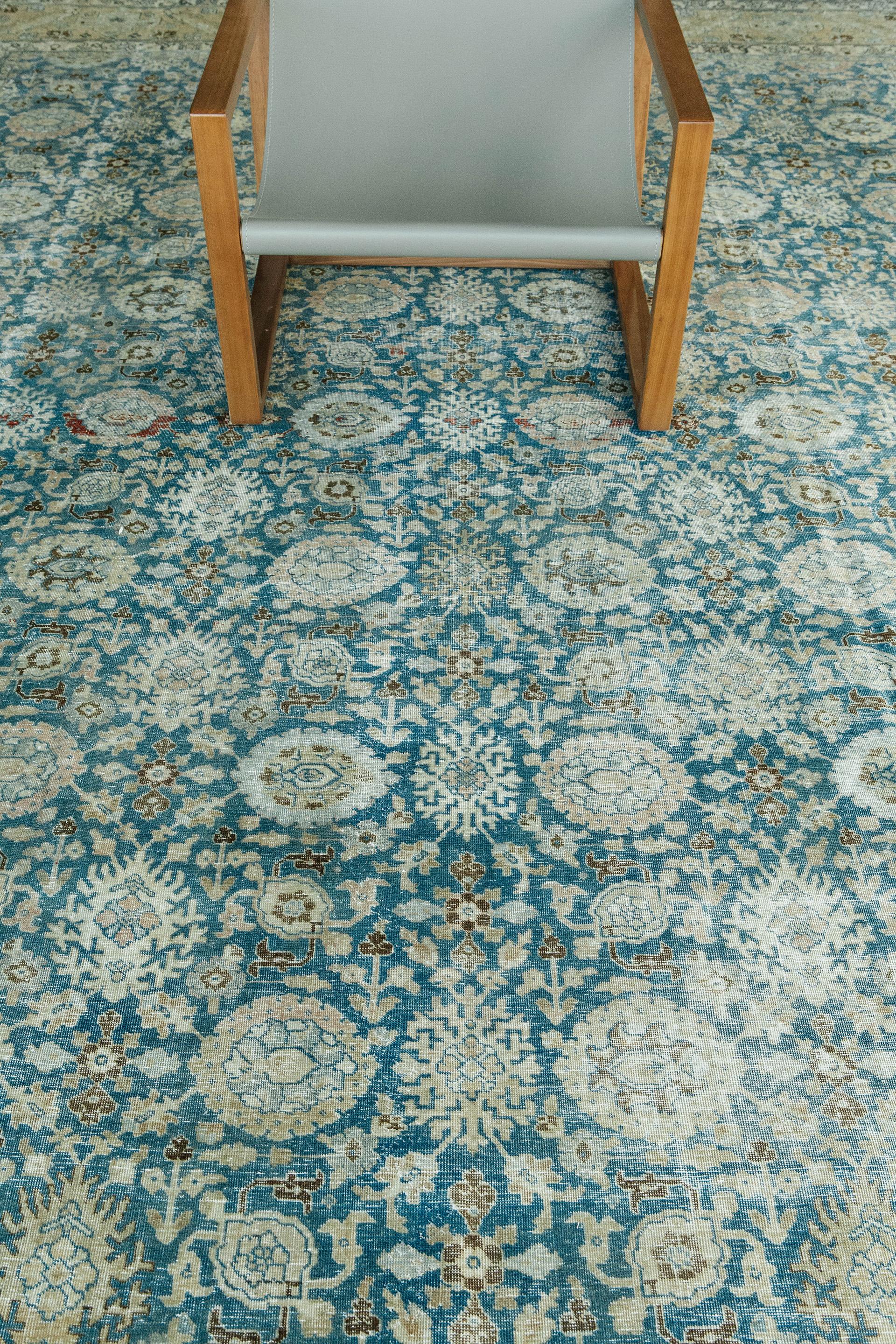 With strict standards of craftsmanship and quality of materials used, this Tabriz rug captures the sophistication and refinement of the classical Safavid Court carpets. A beautiful border surrounding the jewel-toned blue creates a carpet ideal of