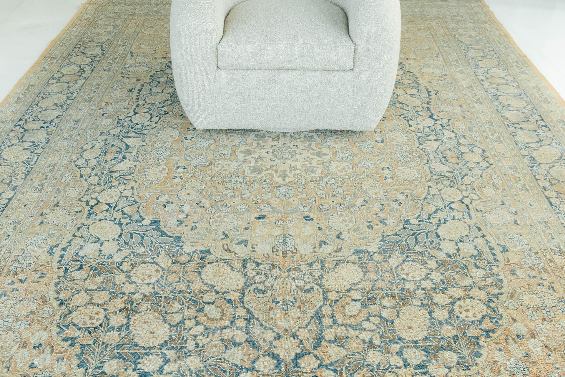 Antique Tabriz warm sand and teal ground with ivory, sage green and taupe elements. Axial design with fields brimming with foliated lattice and floral motifs. Central medallion with pendants at top and bottom. Oval field is enclosed in brimming