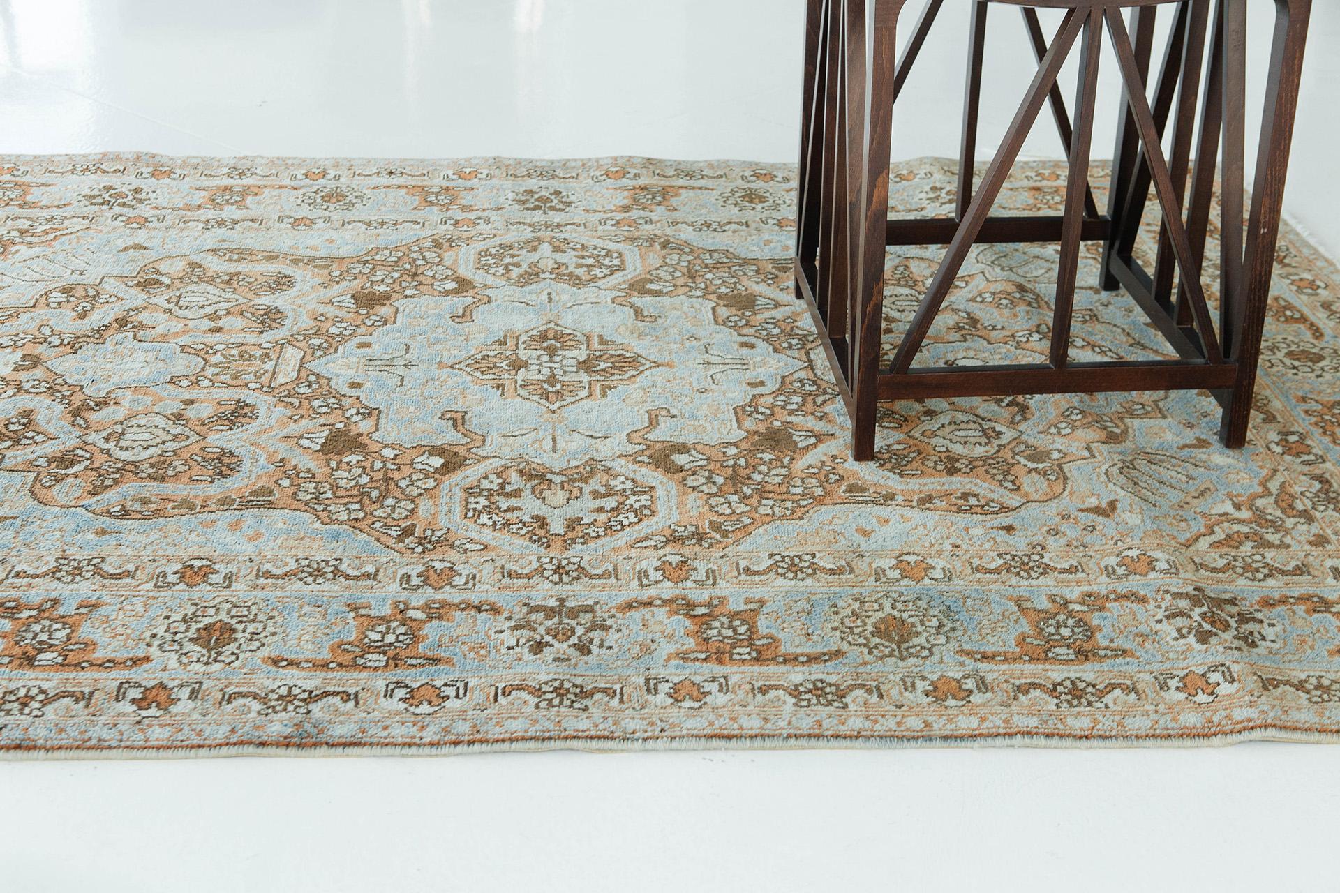 An interplay of terracotta and azure blue establish the base tones in this stunning vintage Tabriz. Ivory and rich brown define motif elements throughout. The rug has an axial composition with a large lobed medallion and pendants in a field of