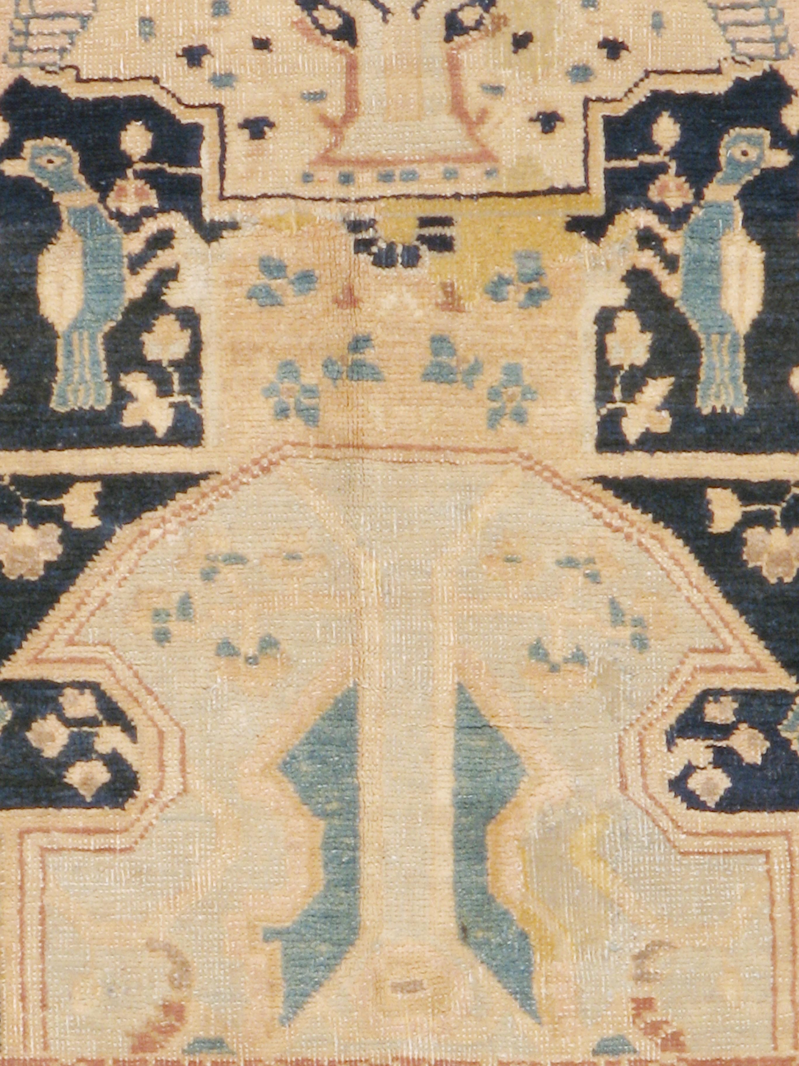 An antique Persian Tabriz rug from the late 19th century. Dated 1304 (1887) and inscribed, this extremely rare Tabriz scatter displays a central beige cartouche gripped by four human hands emerging from angular arabesques, all on a blue-black