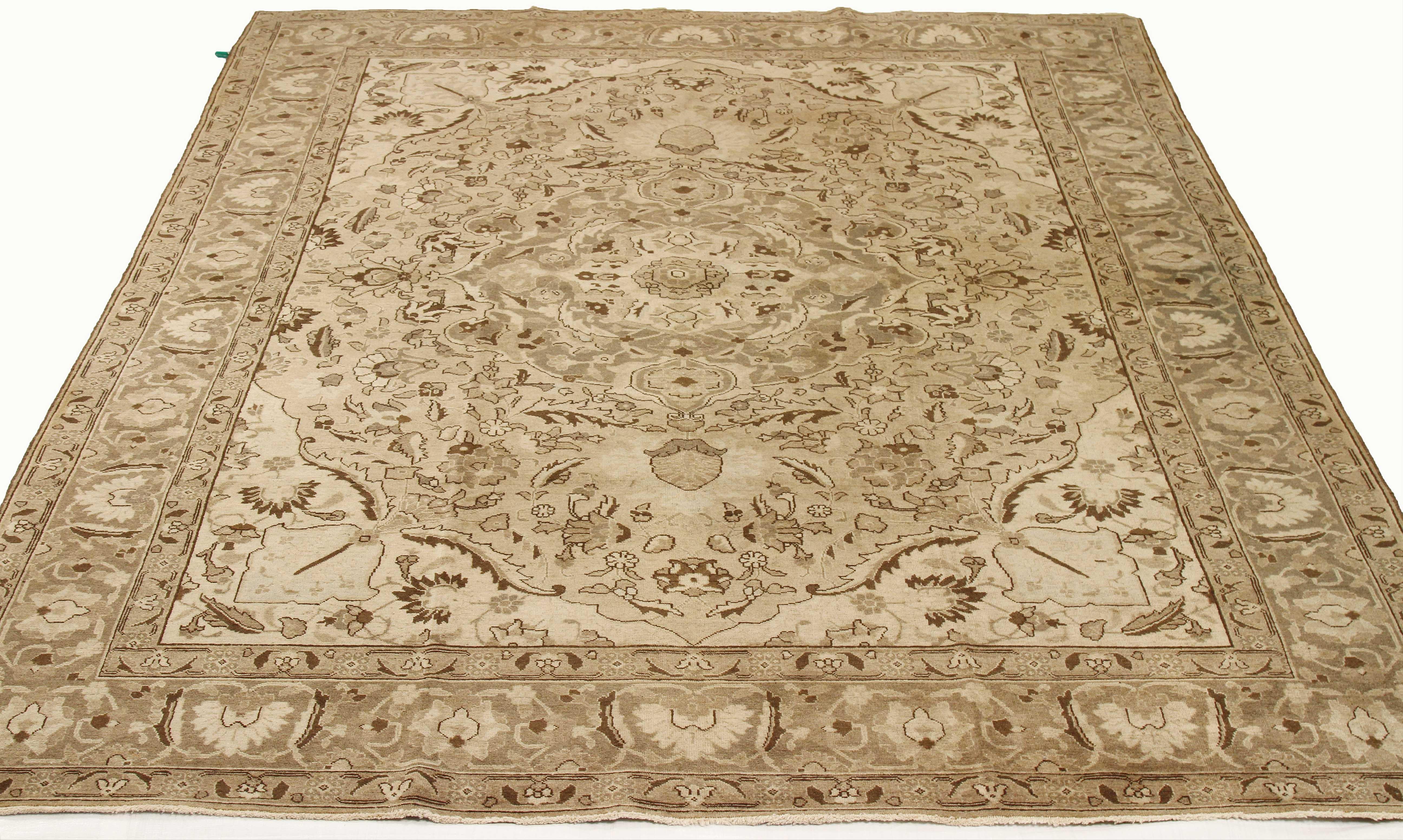 Antique Persian rug handwoven from the finest sheep’s wool and colored with all-natural vegetable dyes that are safe for humans and pets. It’s a traditional Tabriz weaving featuring brown botanical details over an ivory field. It’s a stunning piece