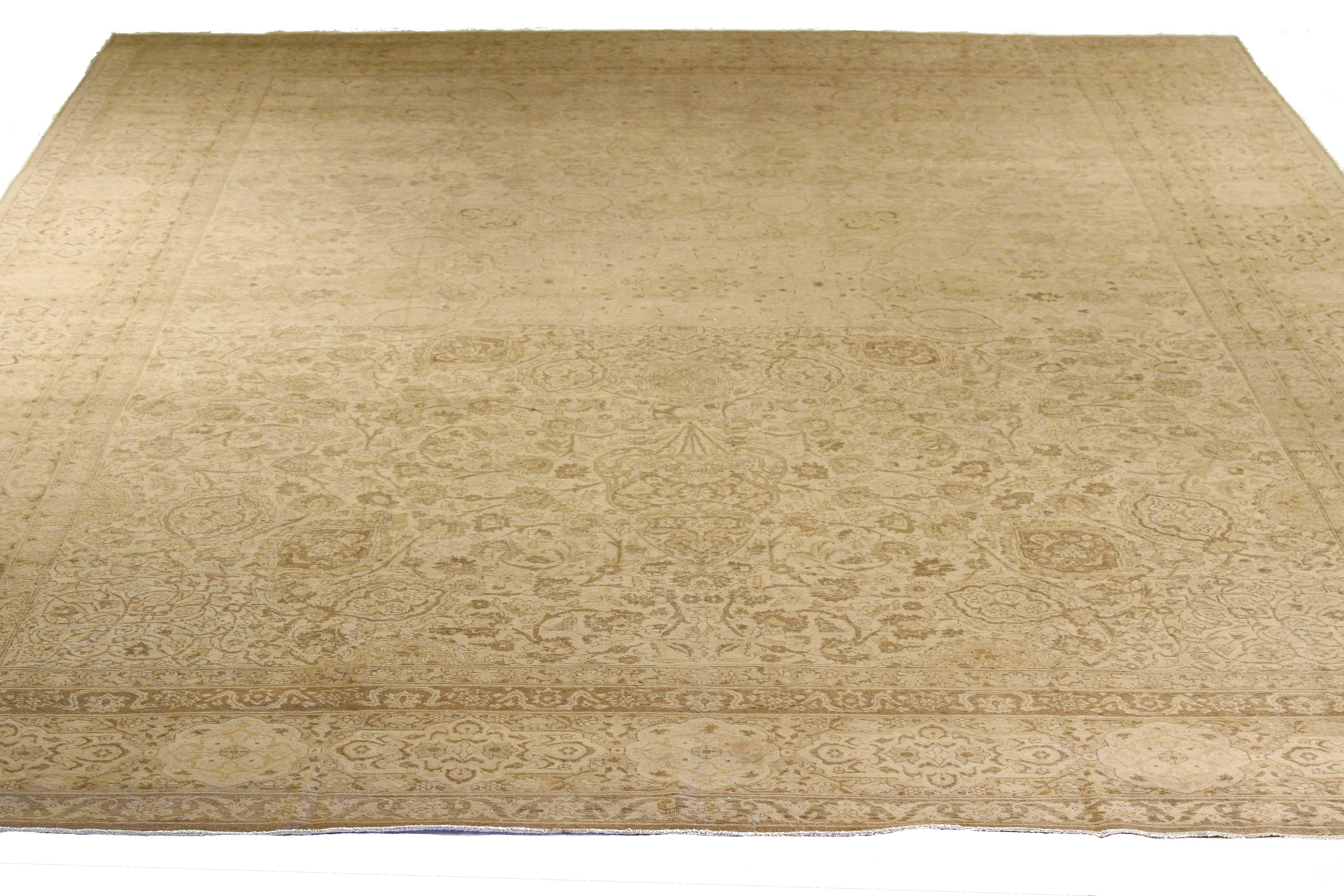 Antique Persian rug handwoven from the finest sheep’s wool and colored with all-natural vegetable dyes that are safe for humans and pets. It’s a traditional Tabriz weaving featuring a lovely ensemble of floral motifs in beige and brown over an ivory