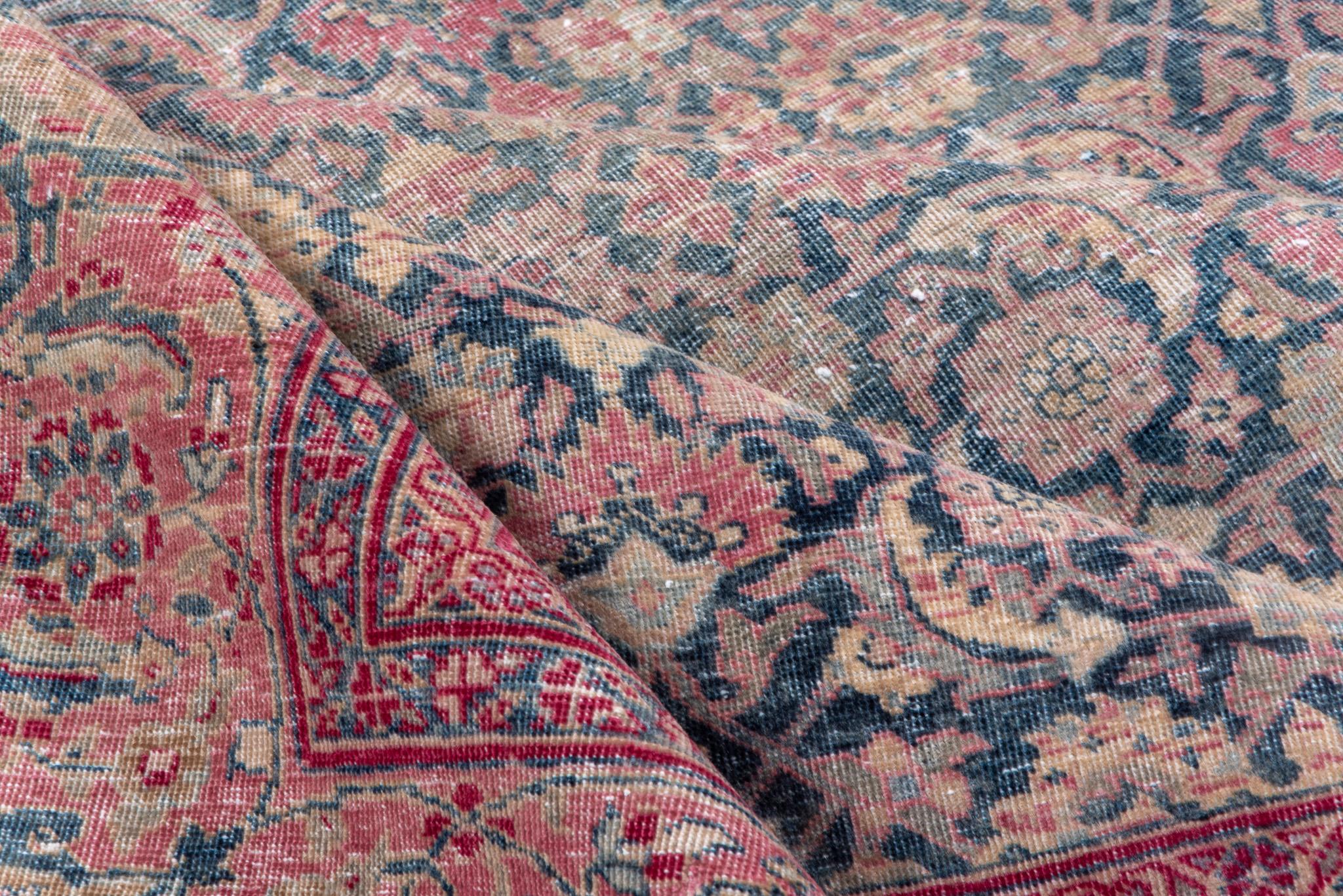 Questo tappeto Tabriz persiano antico presenta un medaglione floreale in blu tenue e uva calda. Il design equilibrato e la delicata combinazione di colori rendono il tappeto perfetto per gli ambienti moderni e tradizionali.