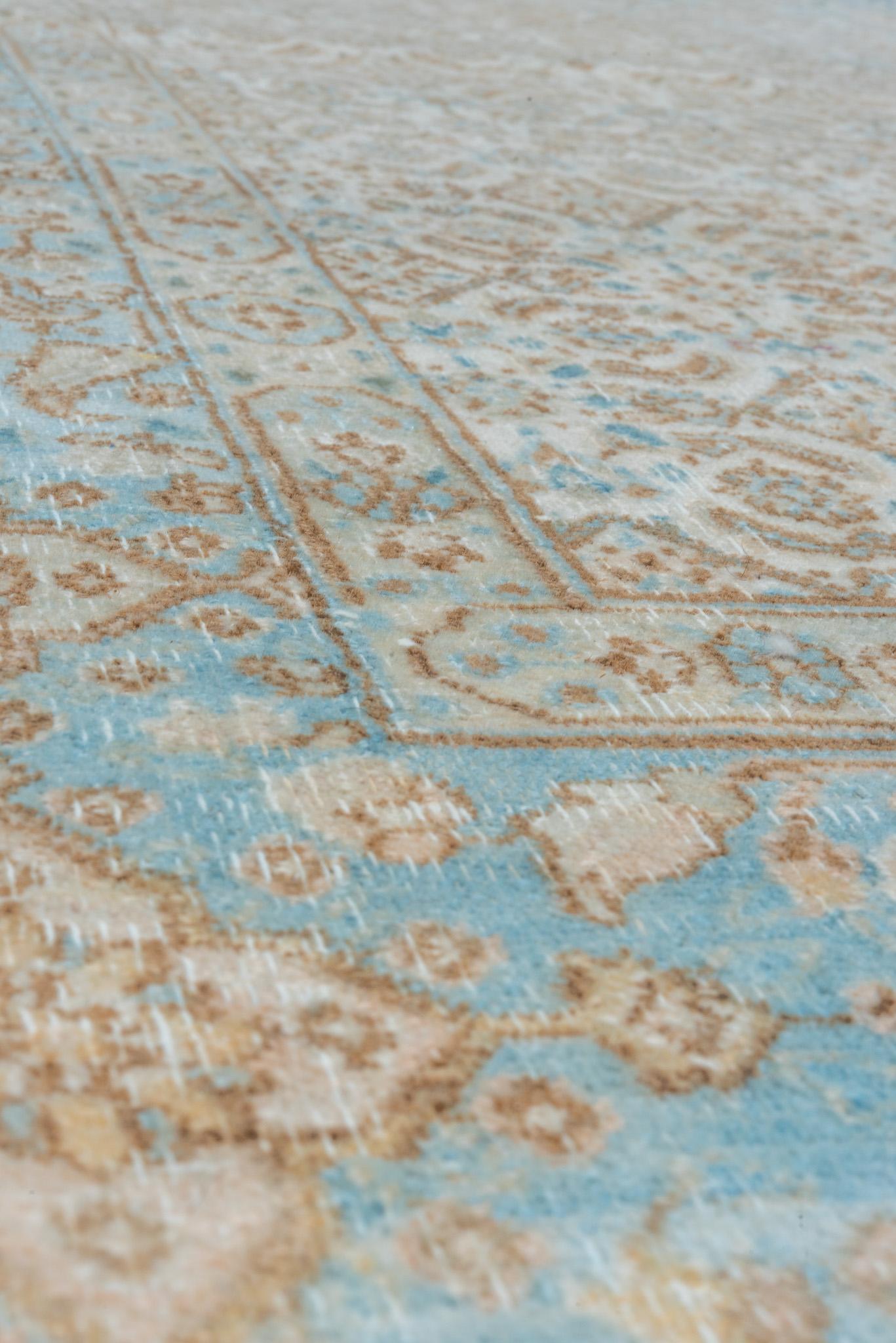 Des motifs floraux complexes en bleu avec des reflets beiges caractérisent ce tapis Tabriz persan ancien. Les couleurs douces et les motifs raffinés du tapis en font une pièce polyvalente pour les intérieurs sophistiqués.