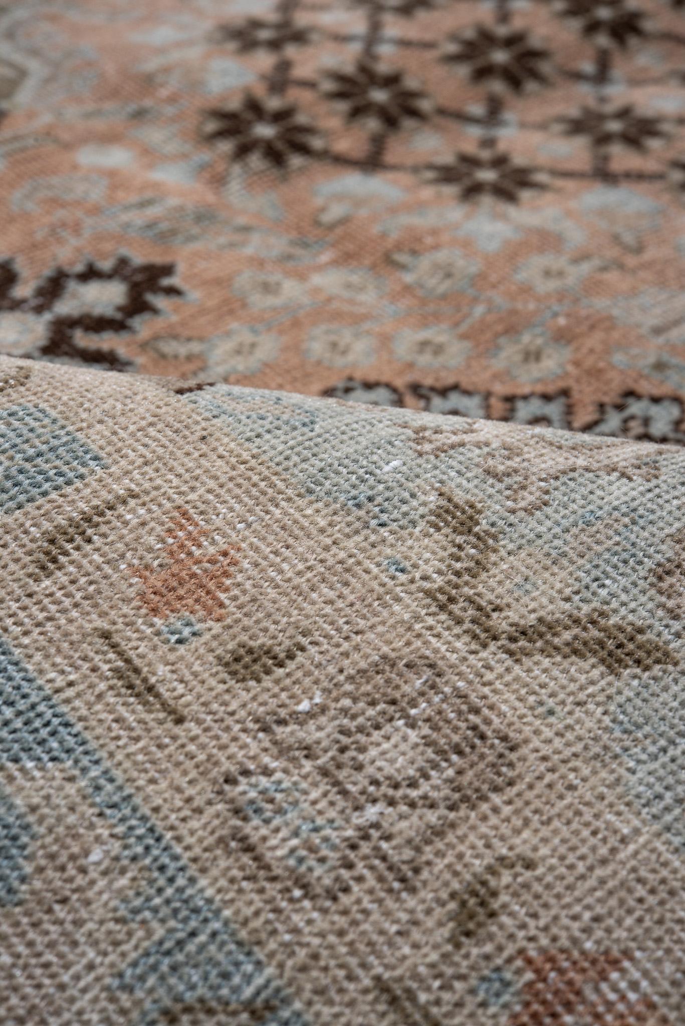 Featuring a large floral medallion in vibrant colors, this Antique Persian Tabriz Rug is a bold statement piece. The rich hues and intricate patterns bring warmth and character to any living space.