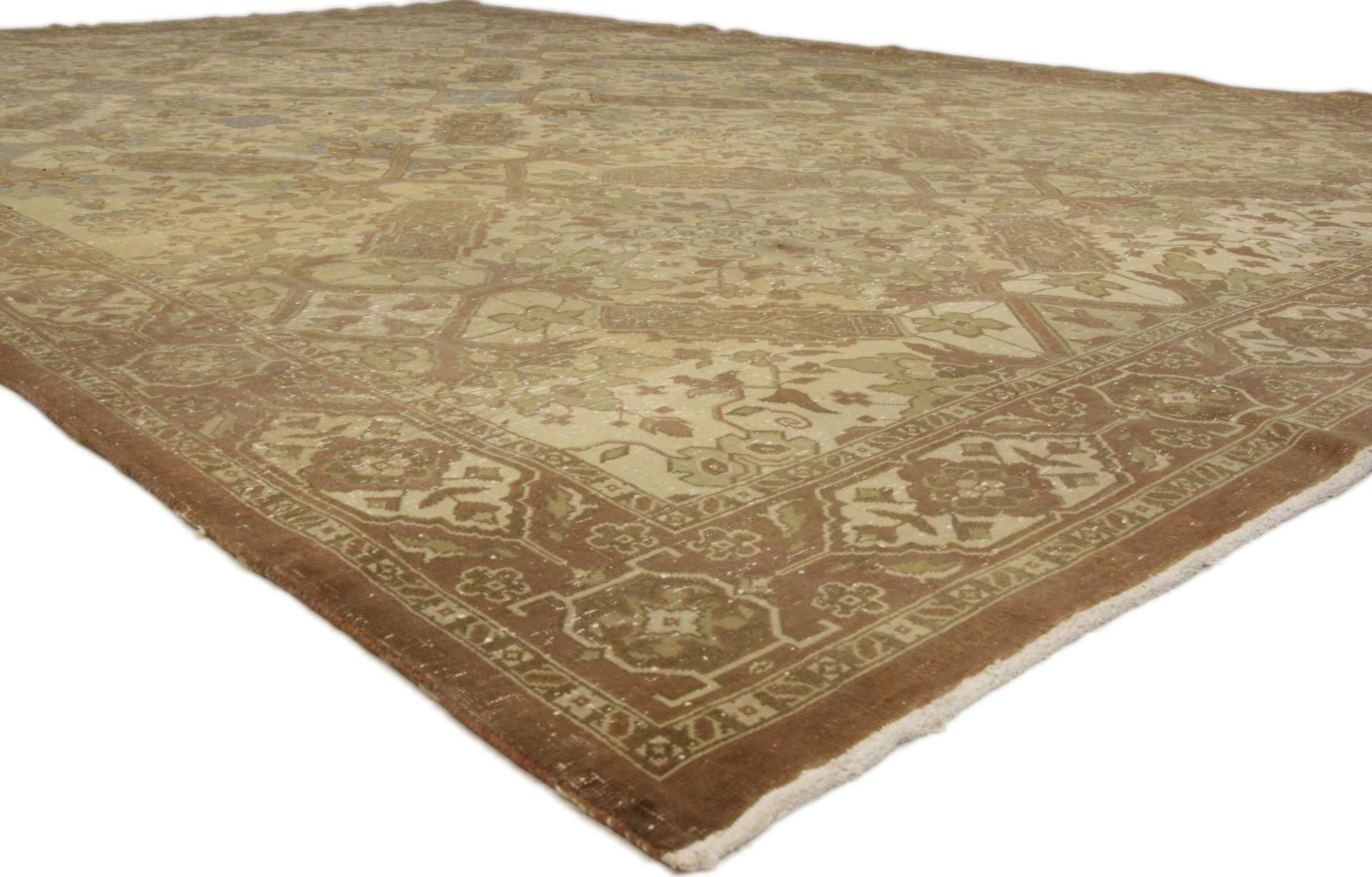 Chaleureux et accueillant avec une sensibilité rustique, ce tapis Tabriz persan ancien en laine noué à la main est prêt à impressionner. Le champ de couleur fauve, usé par le temps, présente un motif botanique sur toute sa surface, entouré d'une