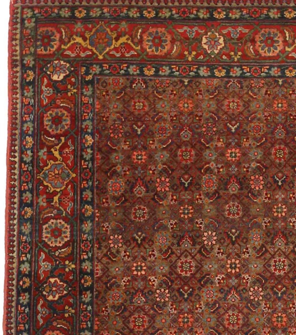 Antique Persian rug handwoven from the finest sheep’s wool and colored with all-natural vegetable dyes that are safe for humans and pets. It’s a traditional Tabriz weaving featuring a lovely ensemble of floral designs in red and green over a mixed