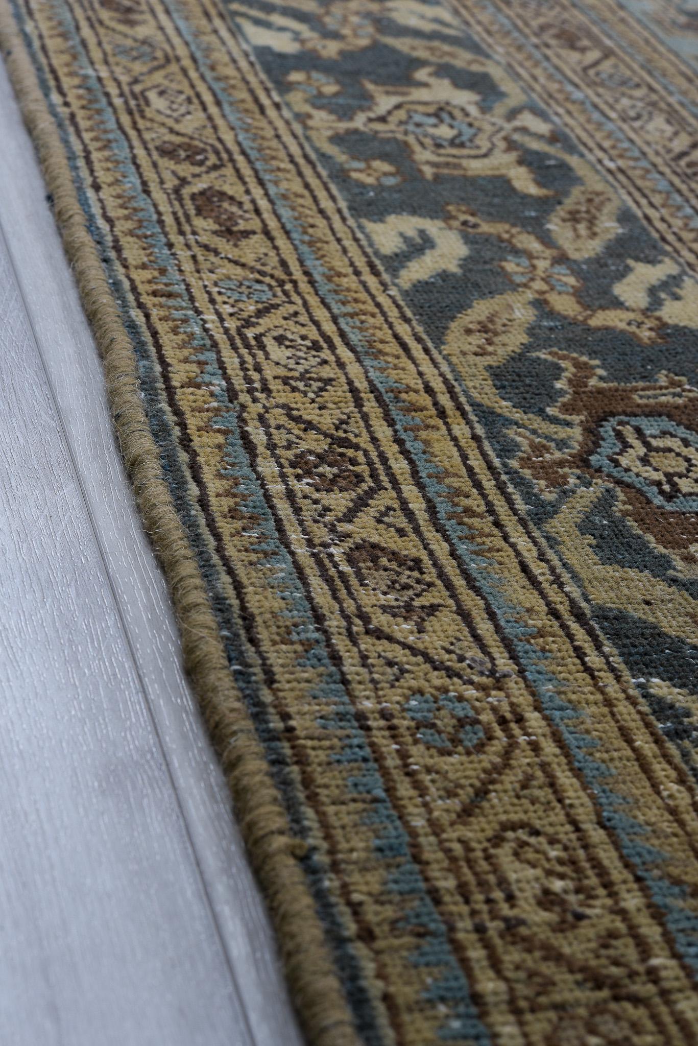 Ce tapis Tabriz persan ancien se distingue par son riche médaillon floral d'un bleu profond et d'un rouge audacieux. Le contraste frappant des couleurs et les détails complexes en font une pièce remarquable pour tout intérieur luxueux.