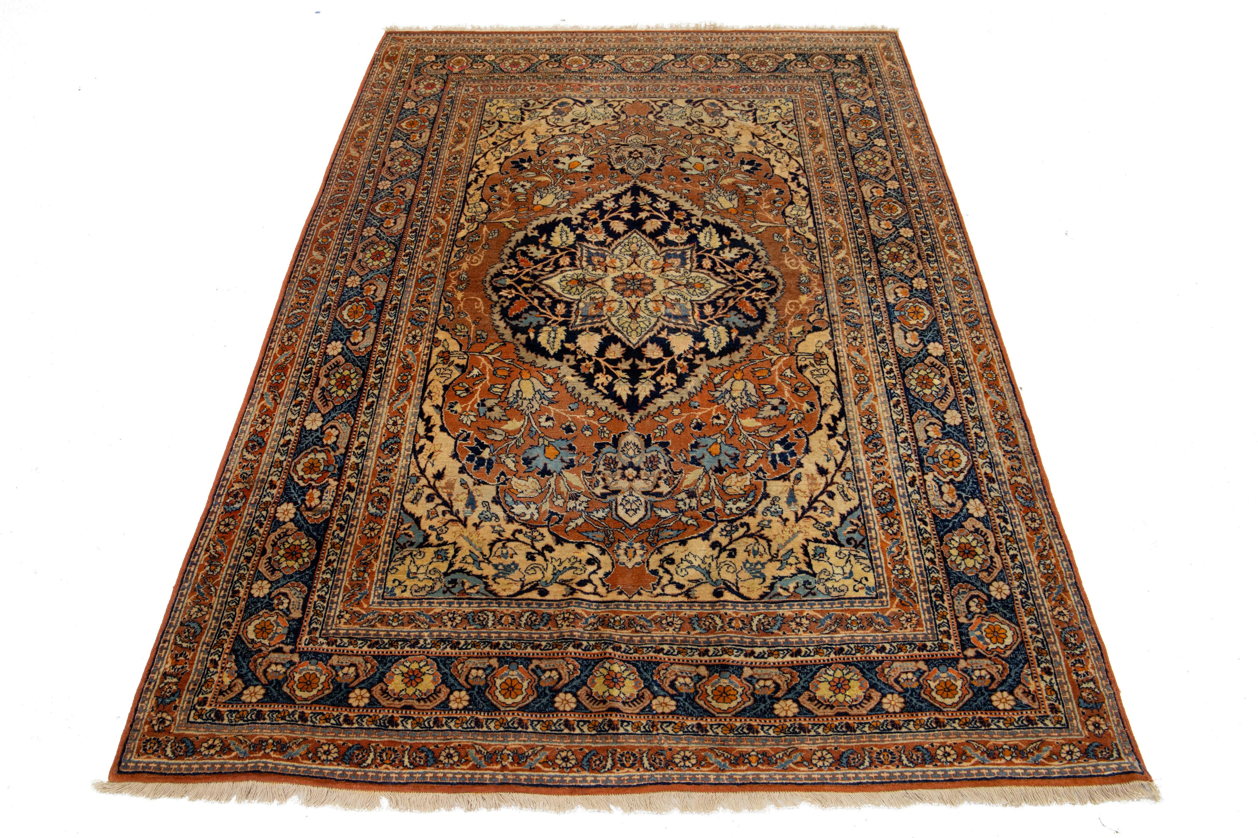 Ce tapis persan Tabriz des années 1920 présente un superbe champ rouille décoré d'un motif floral complexe, rehaussé de riches accents beiges et bleus.

Ce tapis mesure 4'4