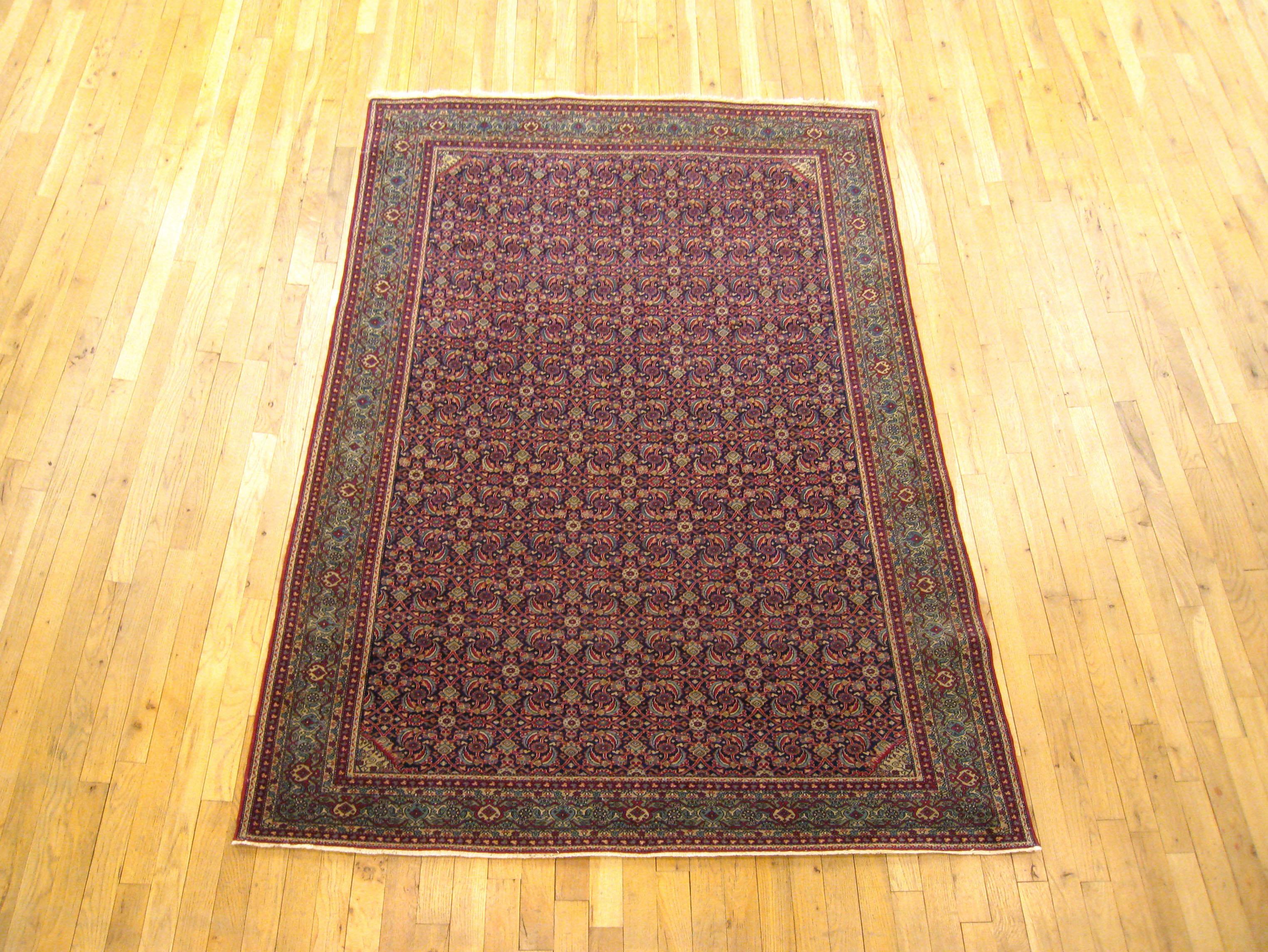 An antique Persian Tehran oriental carpet, size: 7'0 x 4'7, circa 1920. This fine handwoven rug features a handsome repeating Herati design on the navy central field, enclosed within a symmetrical blue-green border. A Classic looking oriental carpet