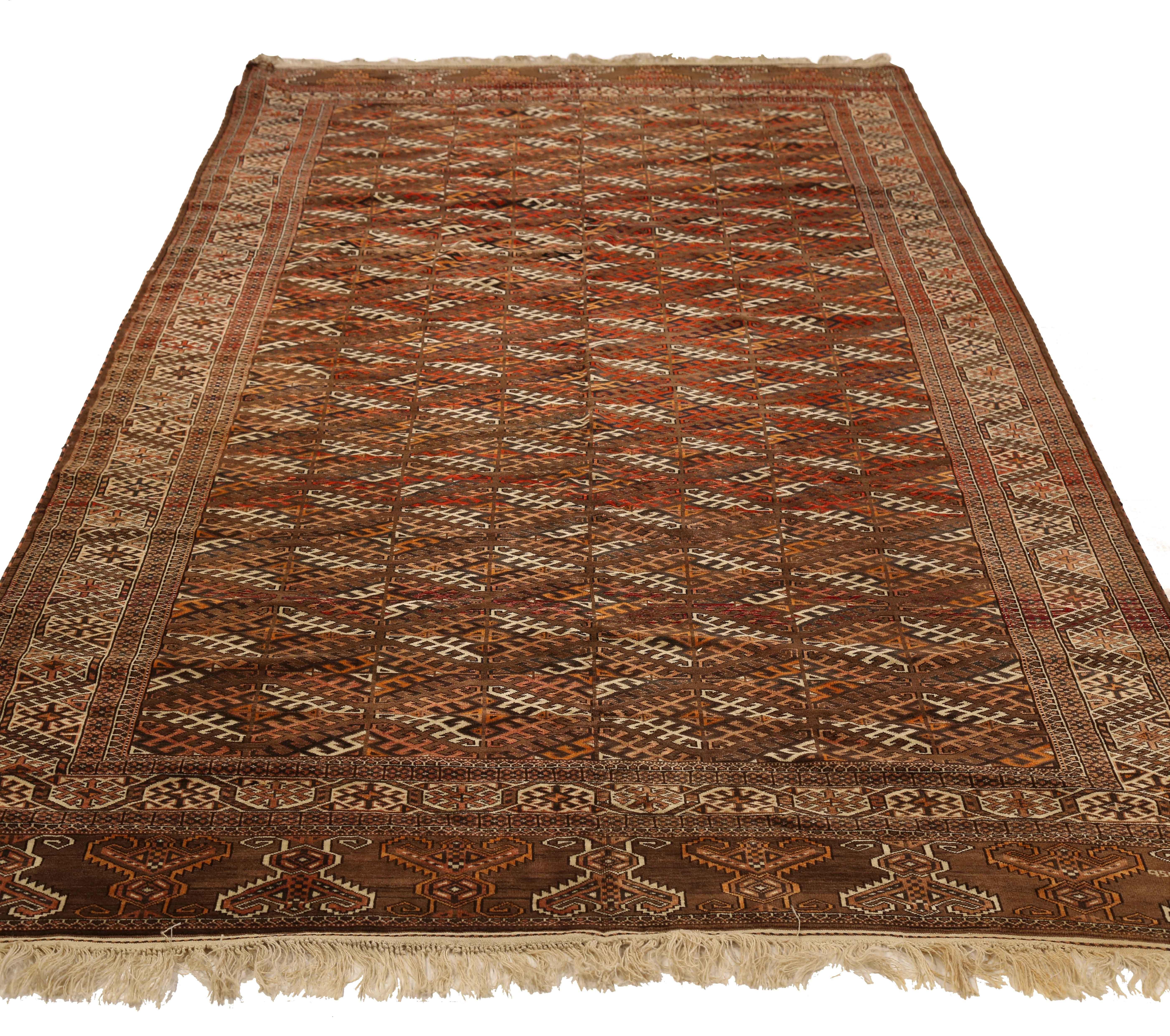 Antique Persian rug handwoven from the finest sheep’s wool and colored with all-natural vegetable dyes that are safe for humans and pets. It’s a traditional Turkmen design featuring diamond details in black, white and brown over a deep red field. It