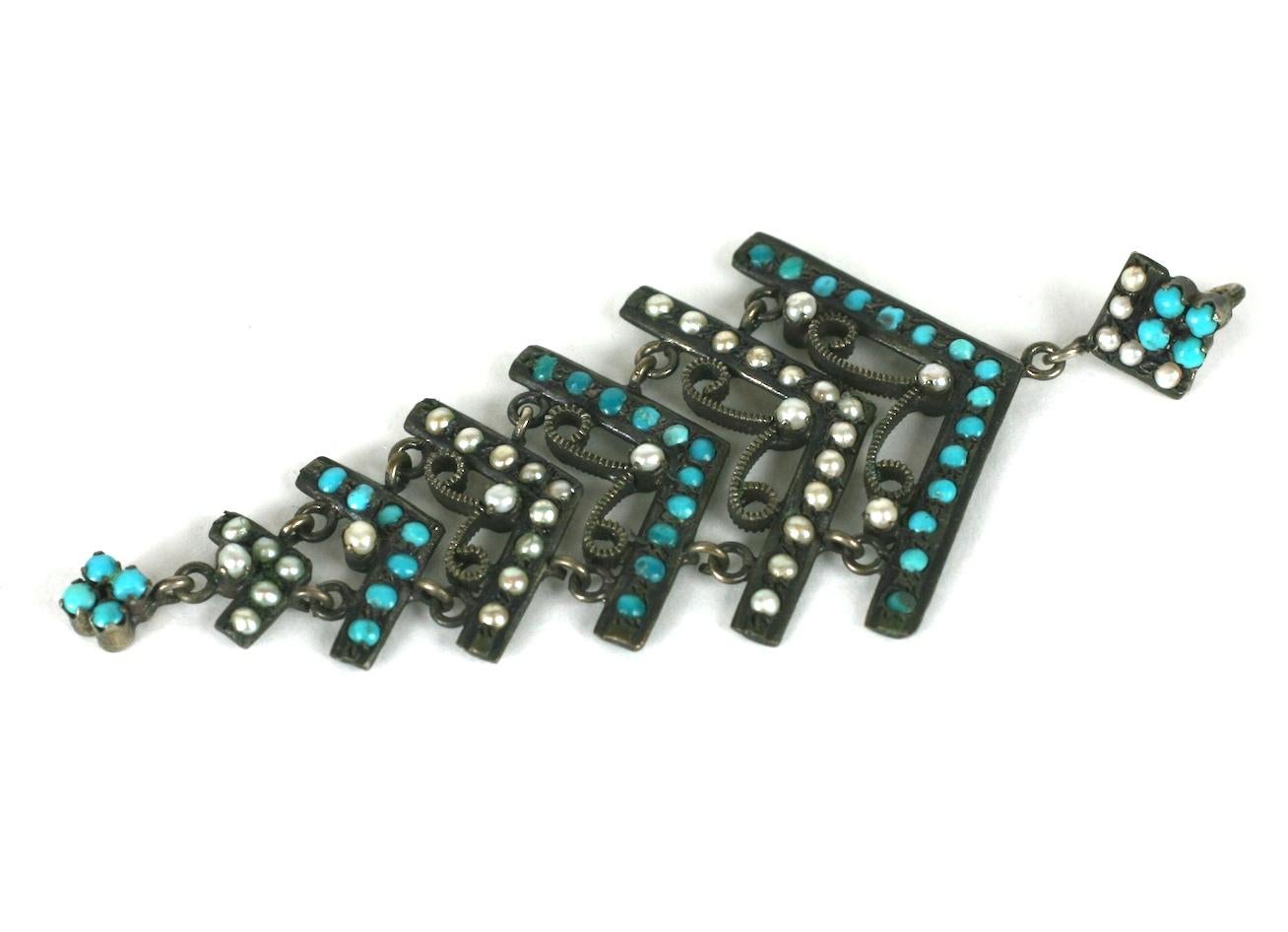 Pendentif ancien en turquoise perse et perle. Charmante goutte articulée avec des rangées de minuscules turquoises de Perse et de fausses perles de rocaille. Métal argenté patiné. 
3.25