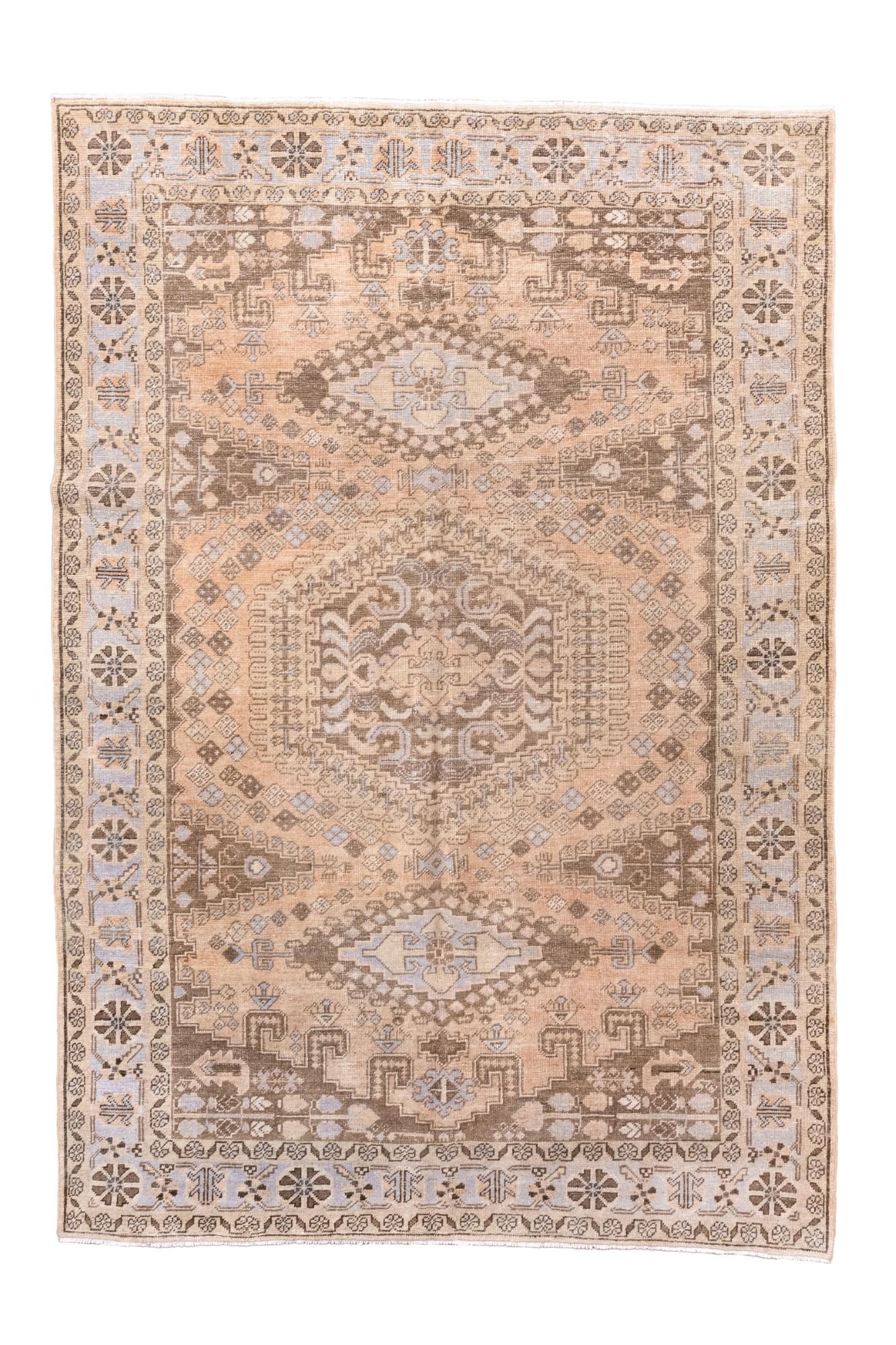 Esta antigua alfombra persa Veecé, tejida hacia 1920, presenta un llamativo diseño geométrico
diseño de medallón rodeado de bordes en capas llenos de estilizados motivos florales y tribales
motivos. Su paleta apagada de beige suave, topo y azul
