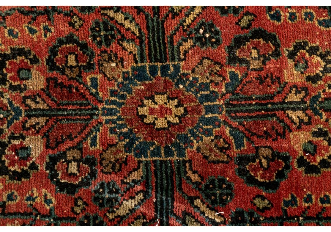 Gewebt in Rost- und Dunkelblautönen mit etwas Grün. Mit kreuzförmigem Mittelmedaillon und breiten und schmalen floralen Schutzborten. Schmale Fransen.

Abmessungen: 32 X 24 3/4