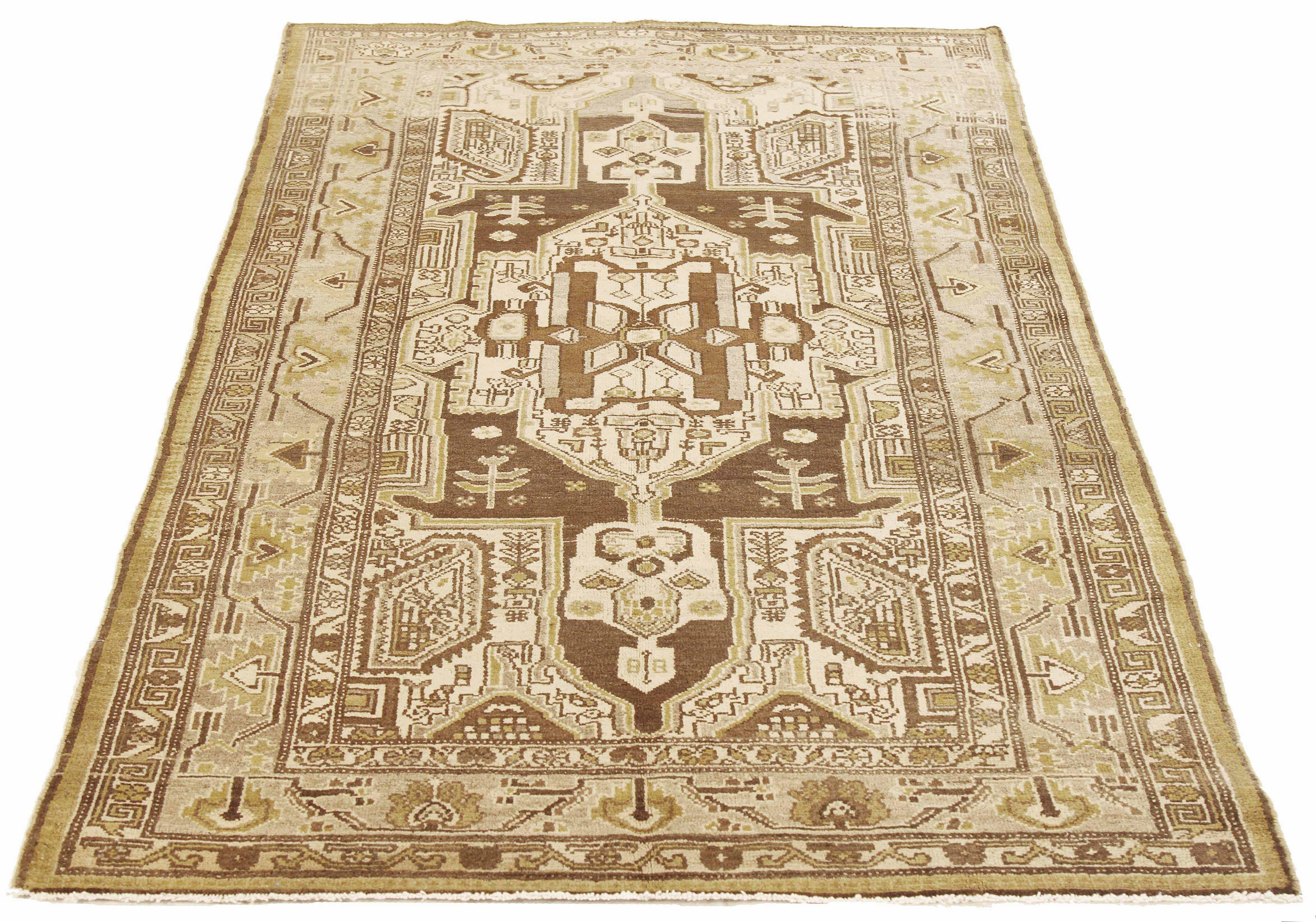 Antique Persian rug handwoven from the finest sheep’s wool and colored with all-natural vegetable dyes that are safe for humans and pets. It’s a traditional Zanjan design featuring geometric tribal details in brown and gold on an ivory field. It’s a