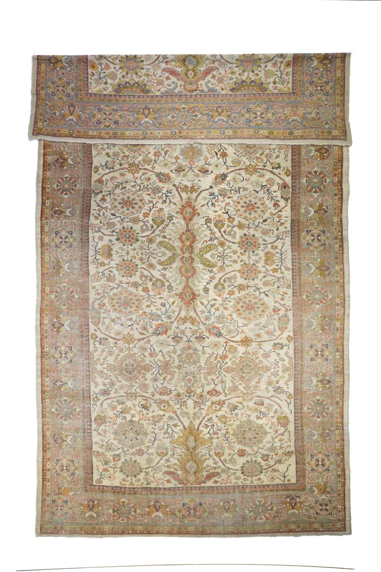 From western Persia, , thuis creamy-straw carepet shows a strong curving arabesque vinery positioning oval palmettes, with a quadruple conjoint rosette and foursickle leaf centre, all accented in rust-red, green and chocolate. Green border with