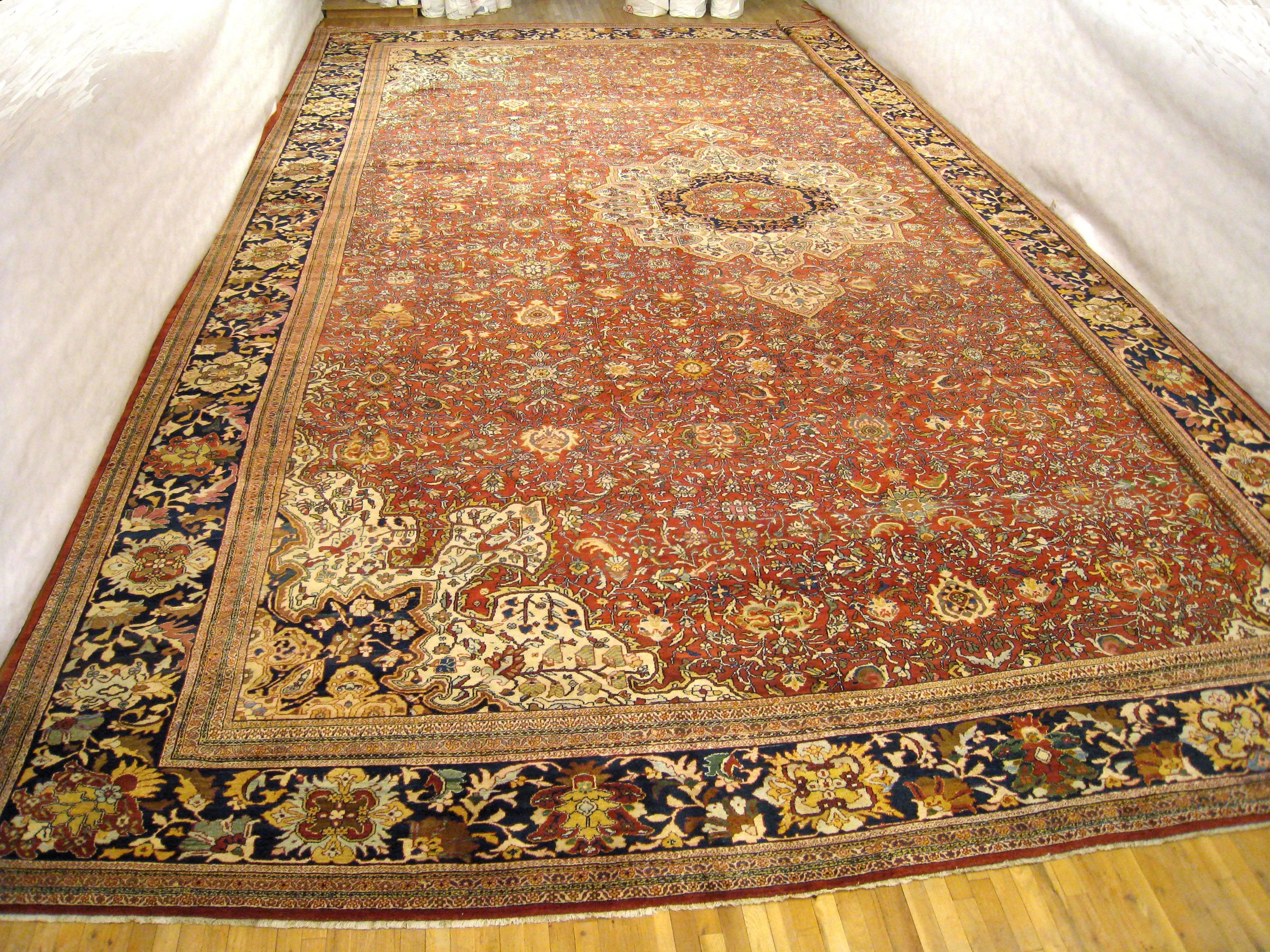 Tapis oriental persan antique Ziegler Sultanabad, vers 1890, dimensions : 27'4 H x 19'1 L. Ce tapis classique en laine noué à la main présente un médaillon central ivoire sur un champ primaire rouge corail, avec des écoinçons réciproques. Entouré
