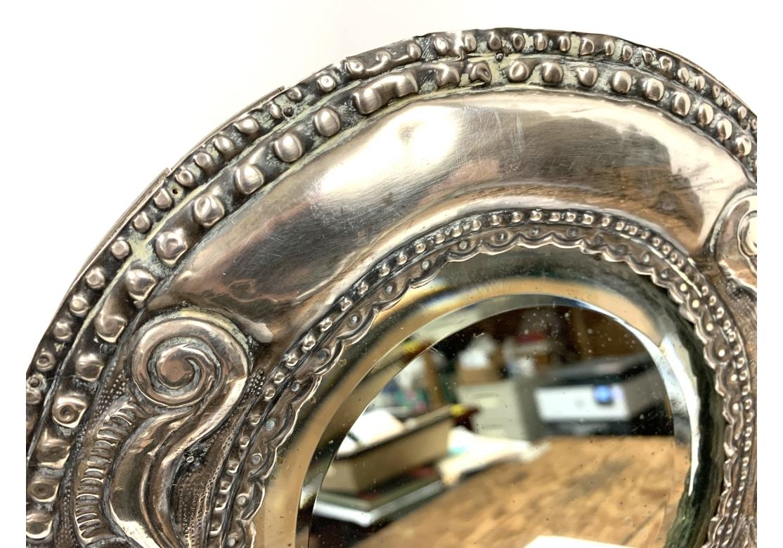 Gran marco de fotos Pereda peruano de plata de ley repujada con trasera de madera abisagrada y soporte de caballete. Con el sello PEREDA 925. Estilo repujado con elaborados motivos de volutas, flores y cuentas.

Dimensiones: 11 1/2
