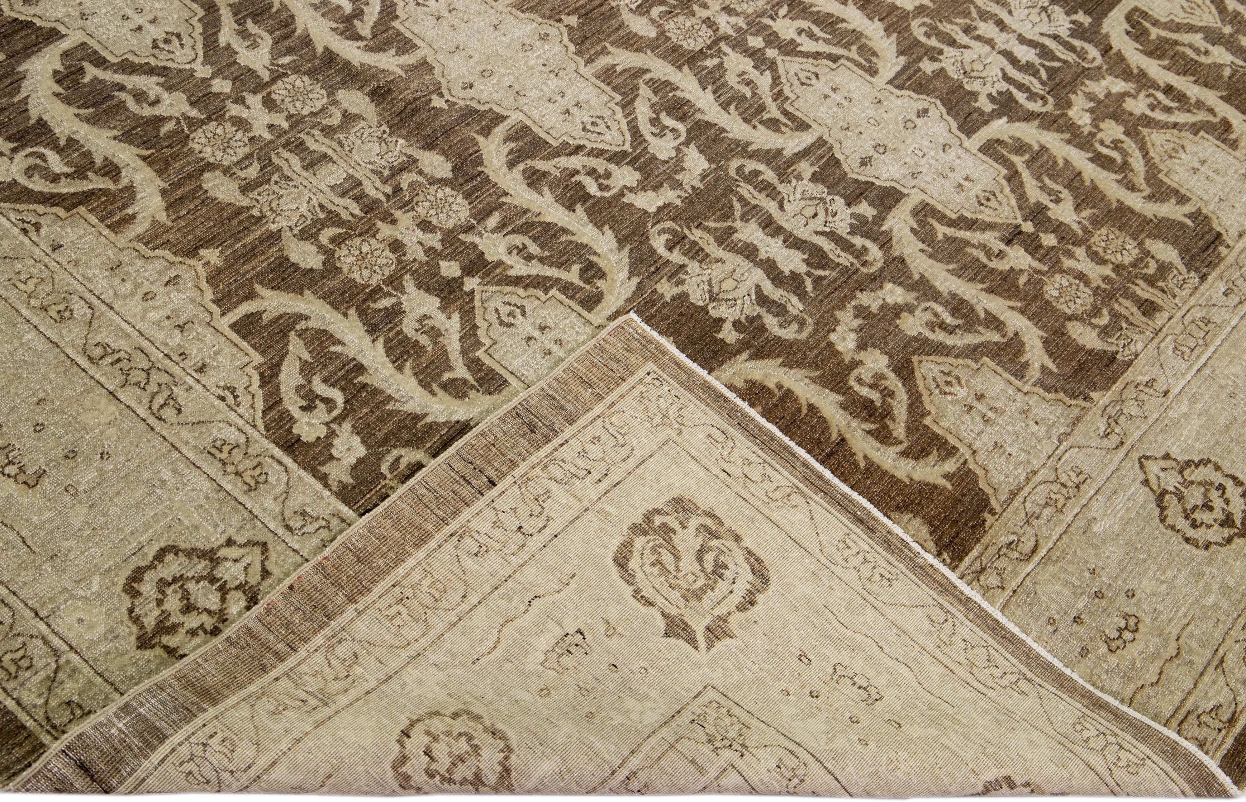 Beautiful hand-knotted antique Peshawar wool rug with the brown field. This Persian rug has a beige frame and accents featuring an all-over traditional floral design. 

This rug measures 8'8