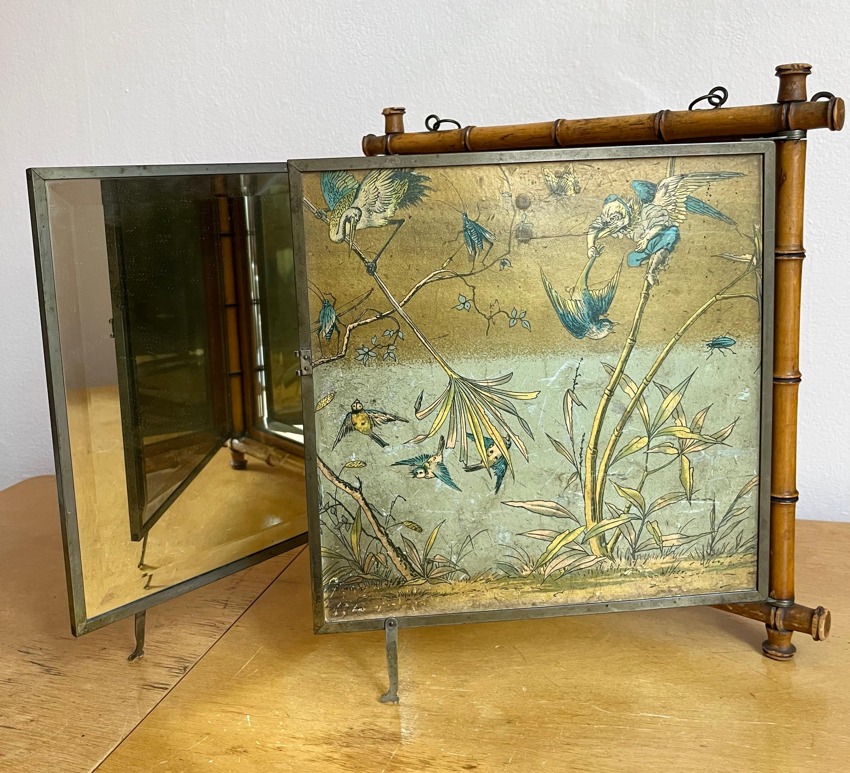 A rare antique tri-fold / tripart beveled mirror by Peter Wiederer & Brothers in New York dates back to 1887. Created in faux (wood) bamboo, this mirror can be hung on the wall with it’s original chain or sit on a table. Two of the sides are