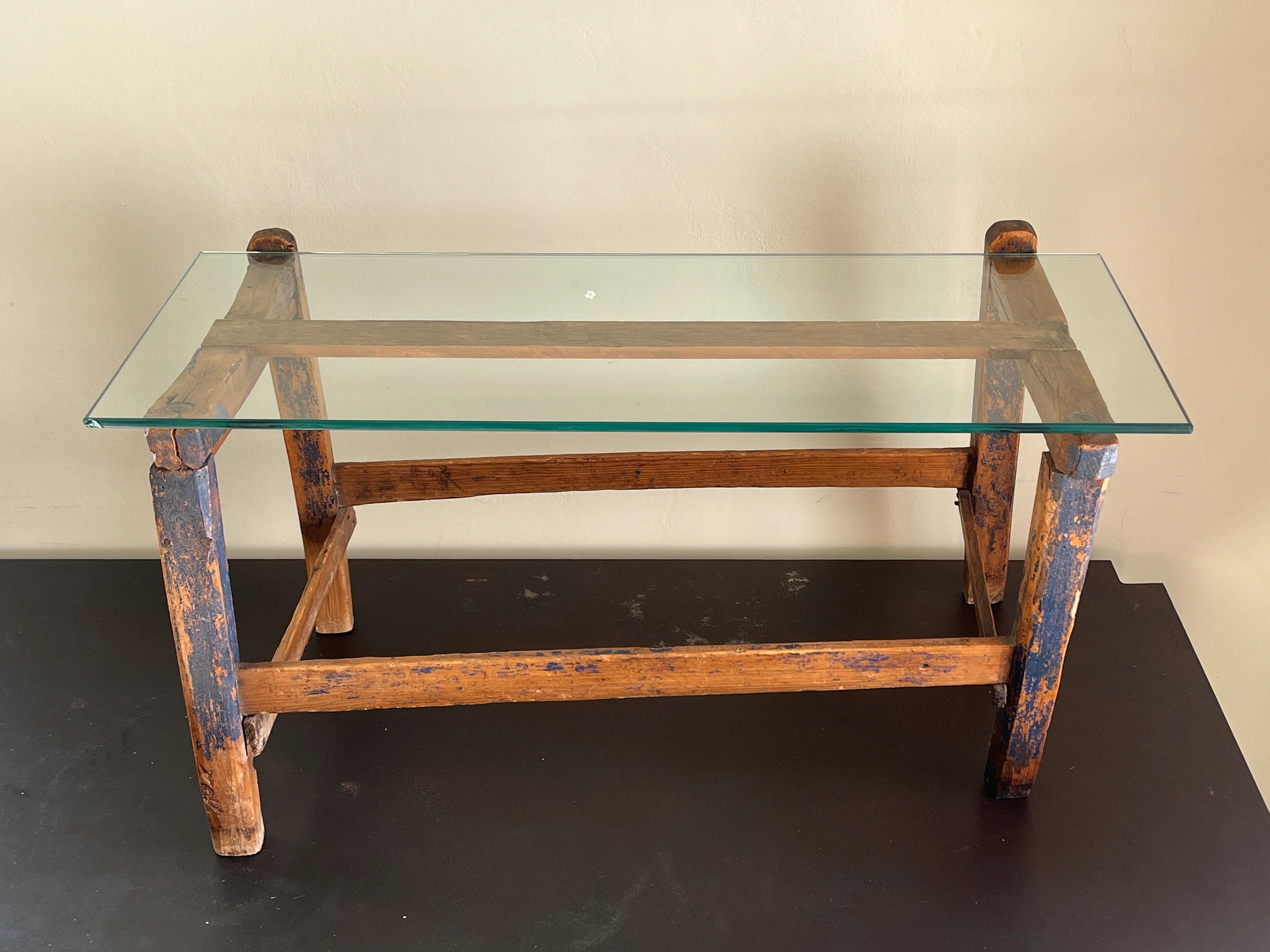 Beautiful patinated blue-painted petite coffee table with glass top. 