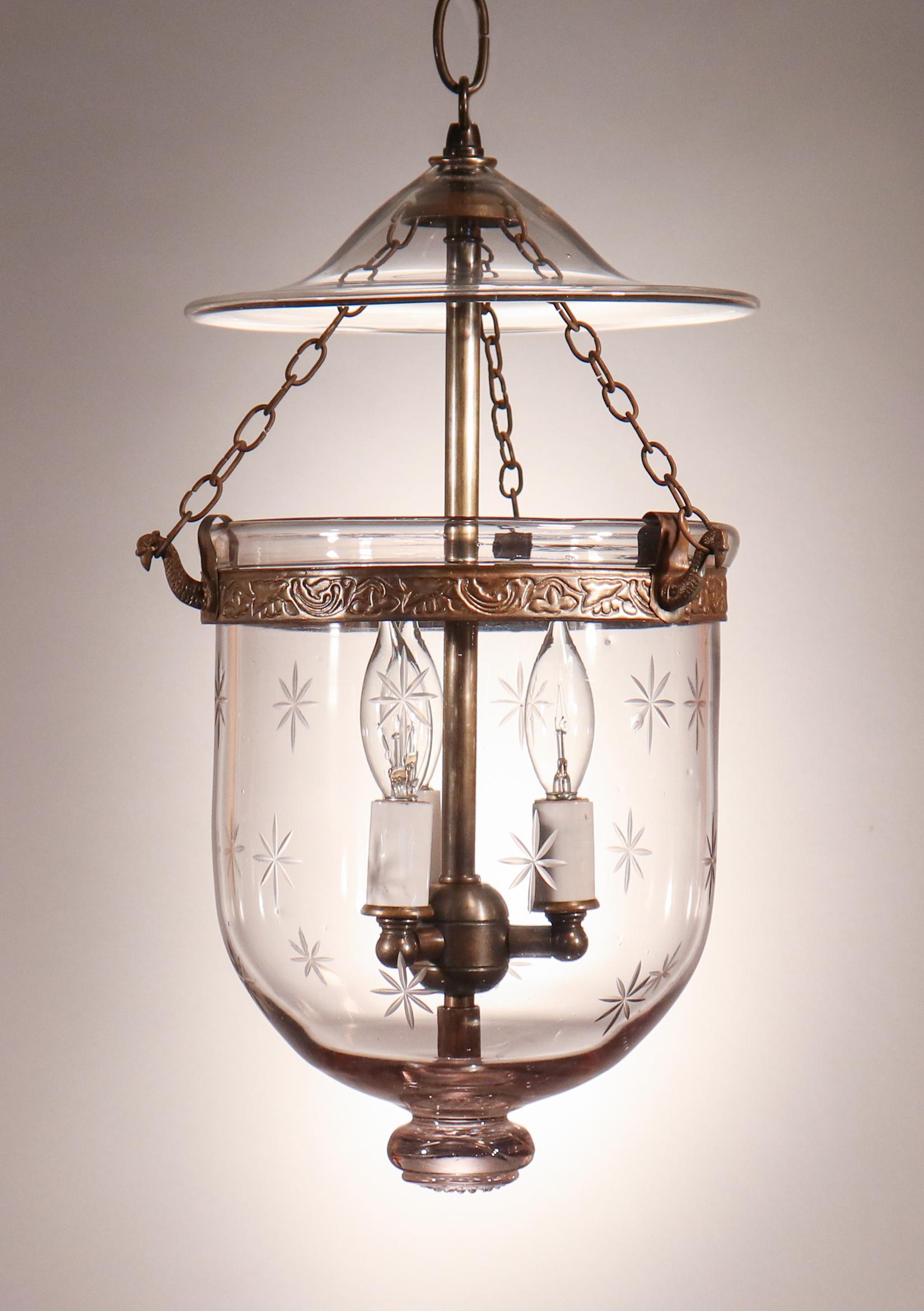 An antique English bell jar lantern with lovely form and an engraved star motif. This petite, circa 1890 pendant features excellent quality hand blown glass and a distinctive glass pontil at bottom. The embossed brass band and strands of chain have