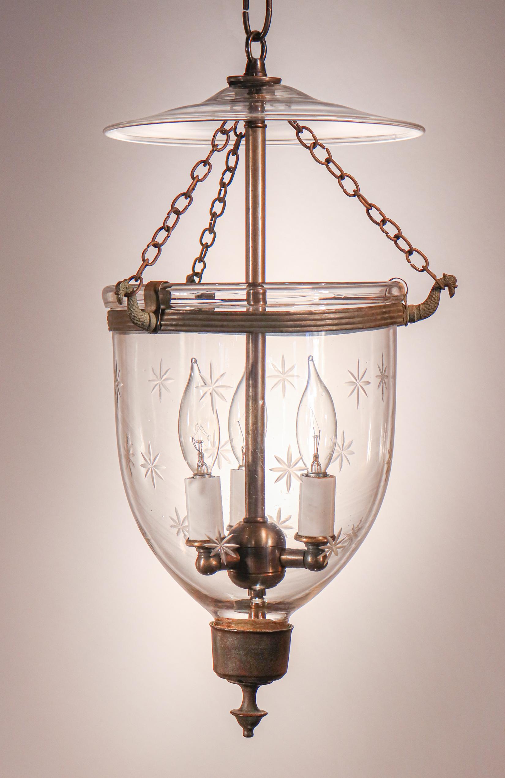 A petite, antique bell jar lantern with lovely form and a finely etched star motif. This circa 1860 pendant features excellent quality hand blown glass and all-original fittings—including smoke bell/lid, brass finial/candle holder base, rolled brass