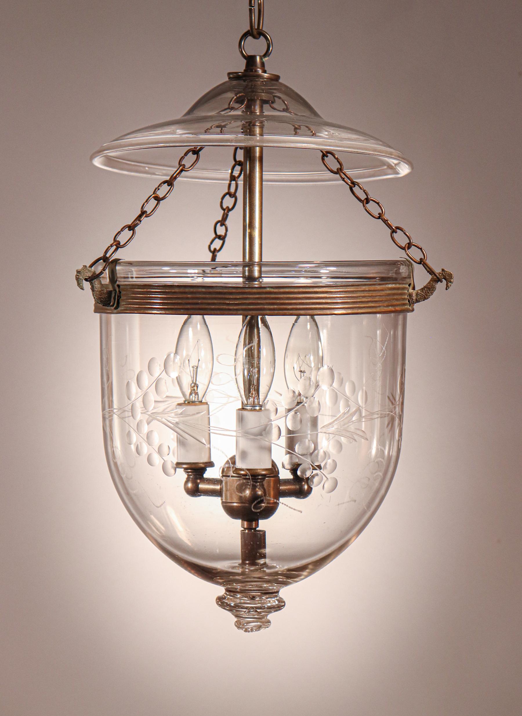 An English hand blown glass bell jar lantern with lovely form and an etched vine motif. This circa 1880 petite pendant light features its original rolled brass band and glass smoke bell/lid. The fixture has been newly electrified with a three-bulb