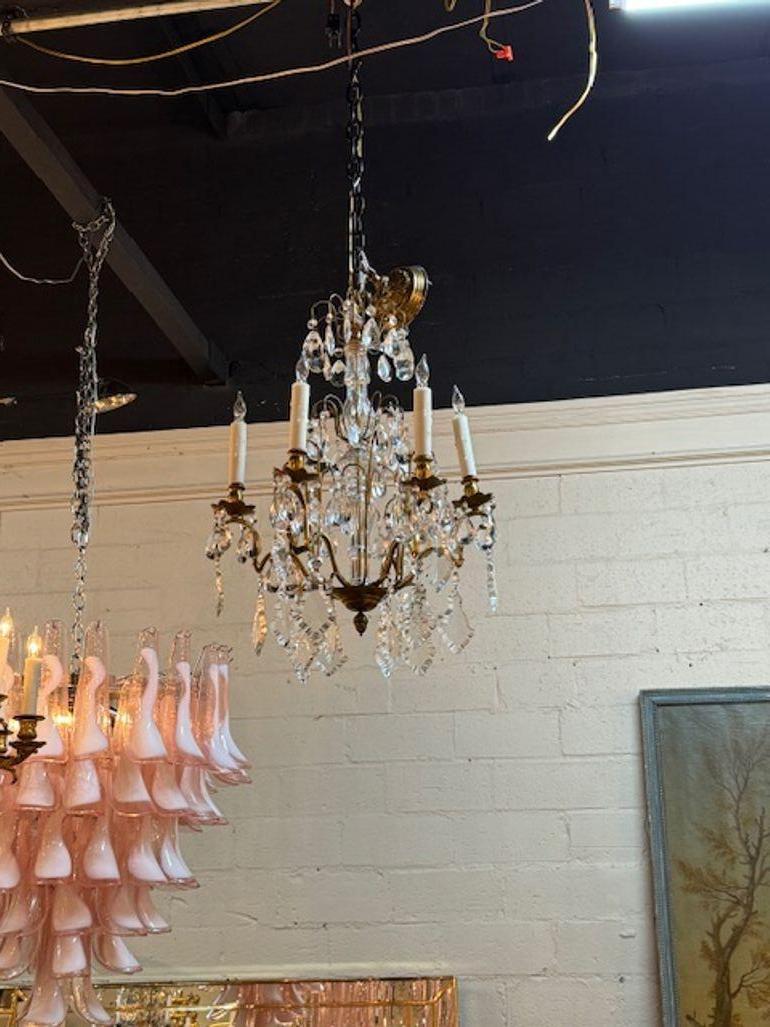 Bellissimo lampadario francese in bronzo e cristallo. Una bellezza scintillante per un piccolo spazio! Questo apparecchio è cablato e viene fornito con una catena e un baldacchino. Pronto per essere appeso! Circa 1920
25h x 18w
