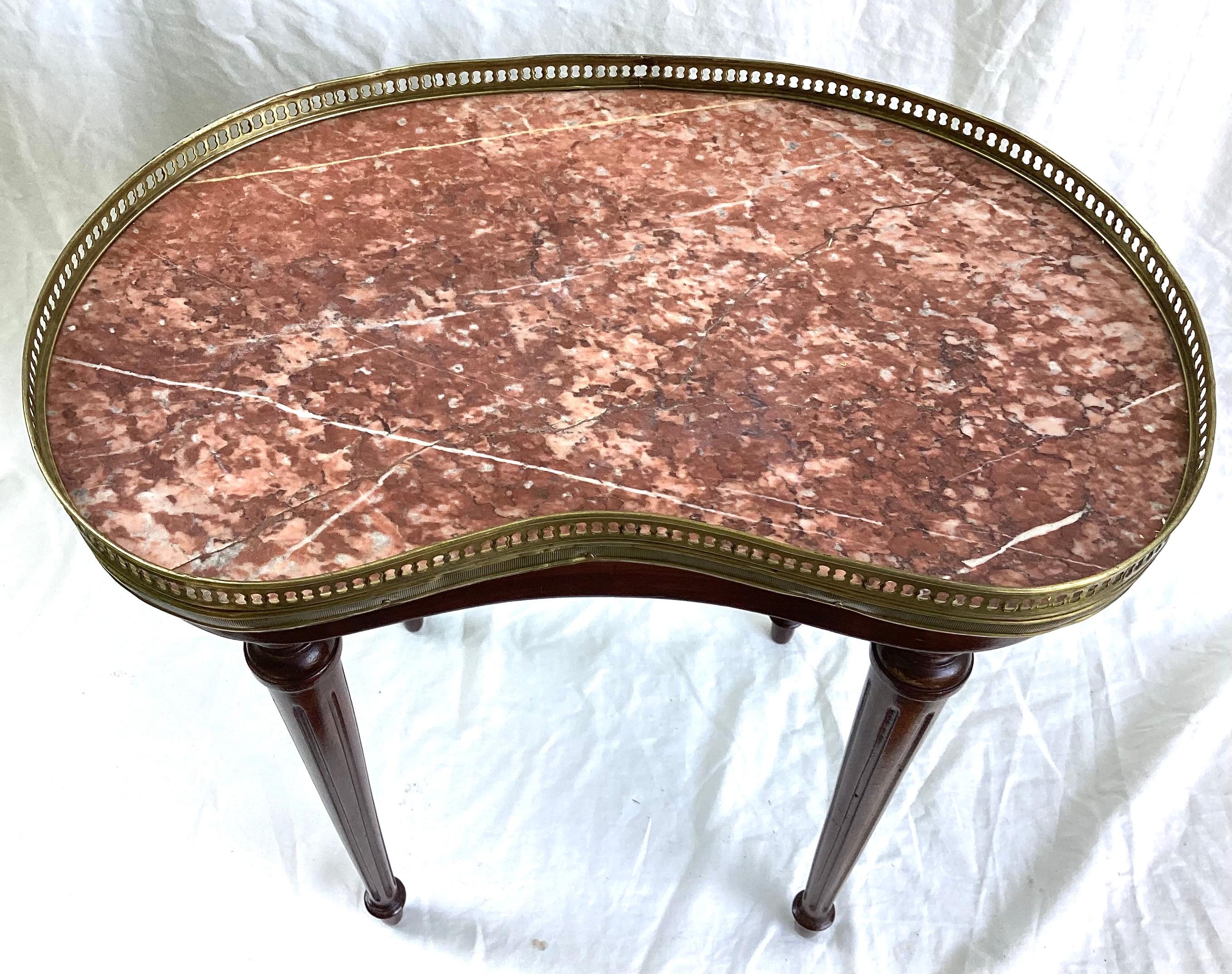 Ancienne Petite Table en Marbre Acajou Louis XVI en forme de rein avec galerie Circa 1920. 21 pouces de large par 12 pouces de profondeur par 20 1/2 pouces de haut jusqu'au sommet de la galerie. Récemment nettoyé et recollé par un professionnel.