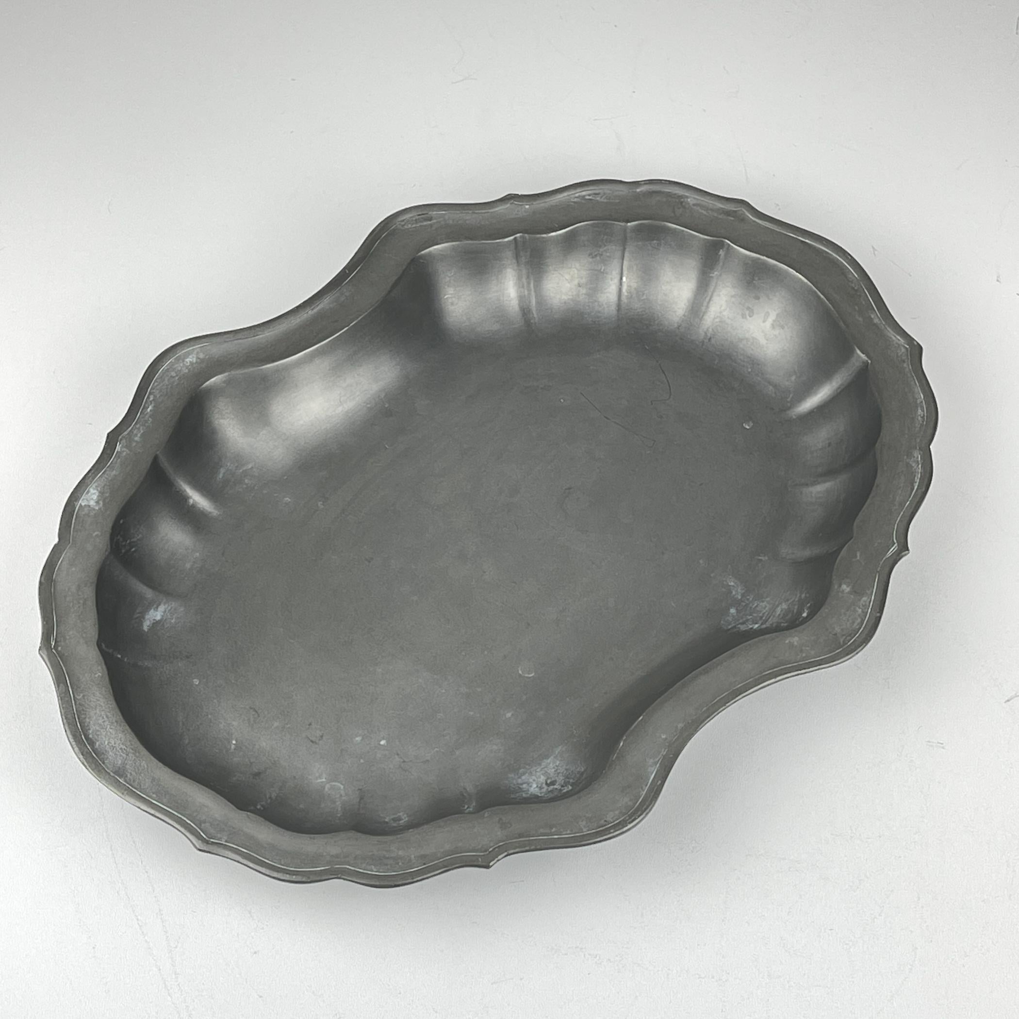 Preciosa bandeja o frutero antiguo de peltre fabricado en Italia a principios del siglo XX. Asombroso plato ovalado de peltre con bordes estriados y una hermosa pátina del tiempo.
El estaño es una aleación metálica maleable compuesta por estaño