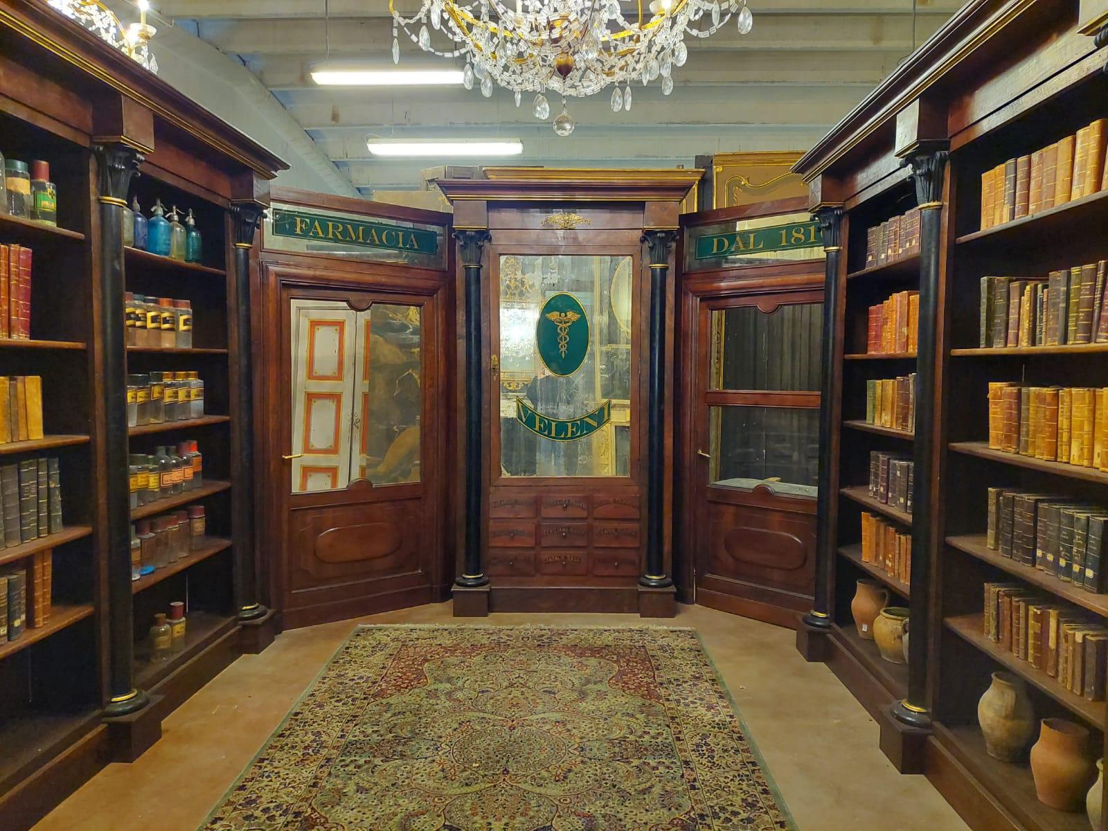 Complete antique pharmacy cabinet, with 3 open bookcases on the sides, 1 bookcase with drawers and 2 original doors with glass and enameled mirror sign. Built in the mid-19th century for a pharmacy shop in Italy (Turin), already conservatively