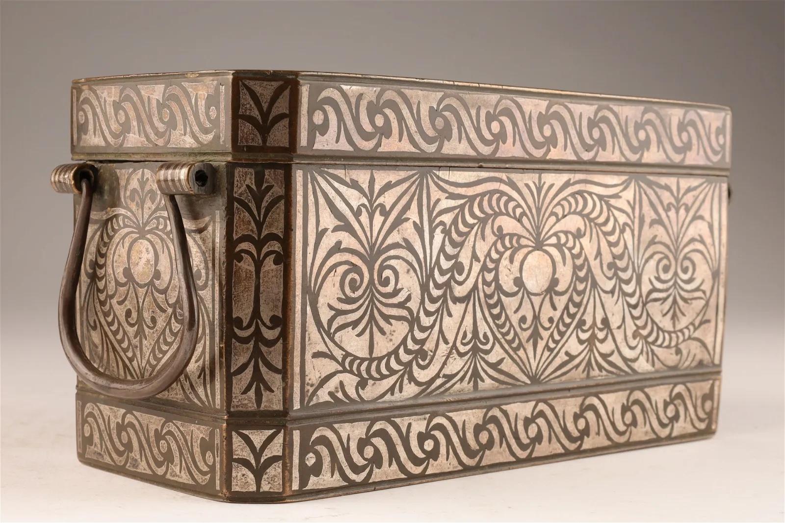 This is a fine example of an early 20th C rectangular bronze betal nut box with beautiful and elaborate silver inlay from Mindanao in the Philippines. The box has a handle on each side and has four compartments inside with silver inlaid lids to hold