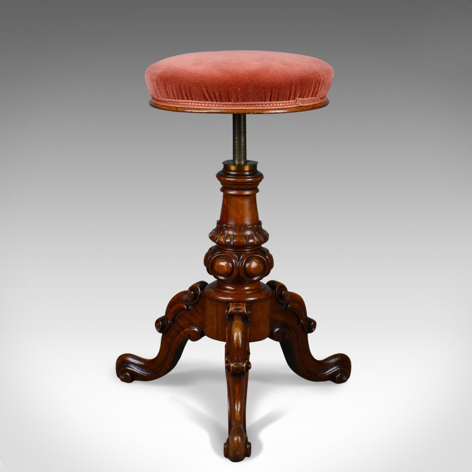 This is an antique piano stool in walnut. An adjustable, English, Victorian music seat dating to circa 1860.

Beautifully made in solid walnut with a waxed finish and desirable aged patina
Raised on a tripod of sturdy cabriole legs 
Inverted,