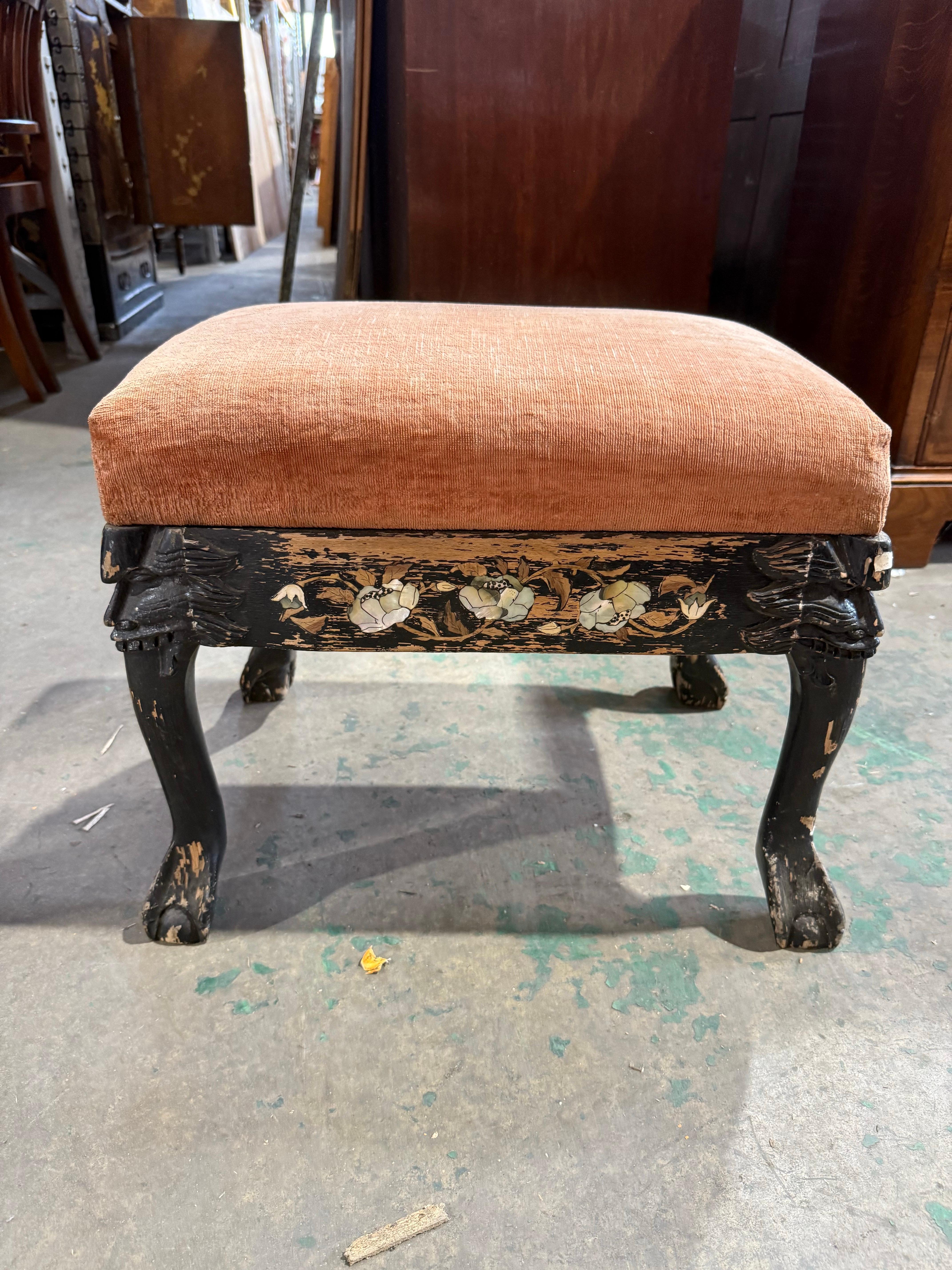 Un suggestivo sgabello per pianoforte antico con una struttura in legno intagliata a mano e un suggestivo intarsio floreale in madreperla lungo il grembiule. La verniciatura dello sgabello è incantevolmente rovinata, rivelando strati di età e