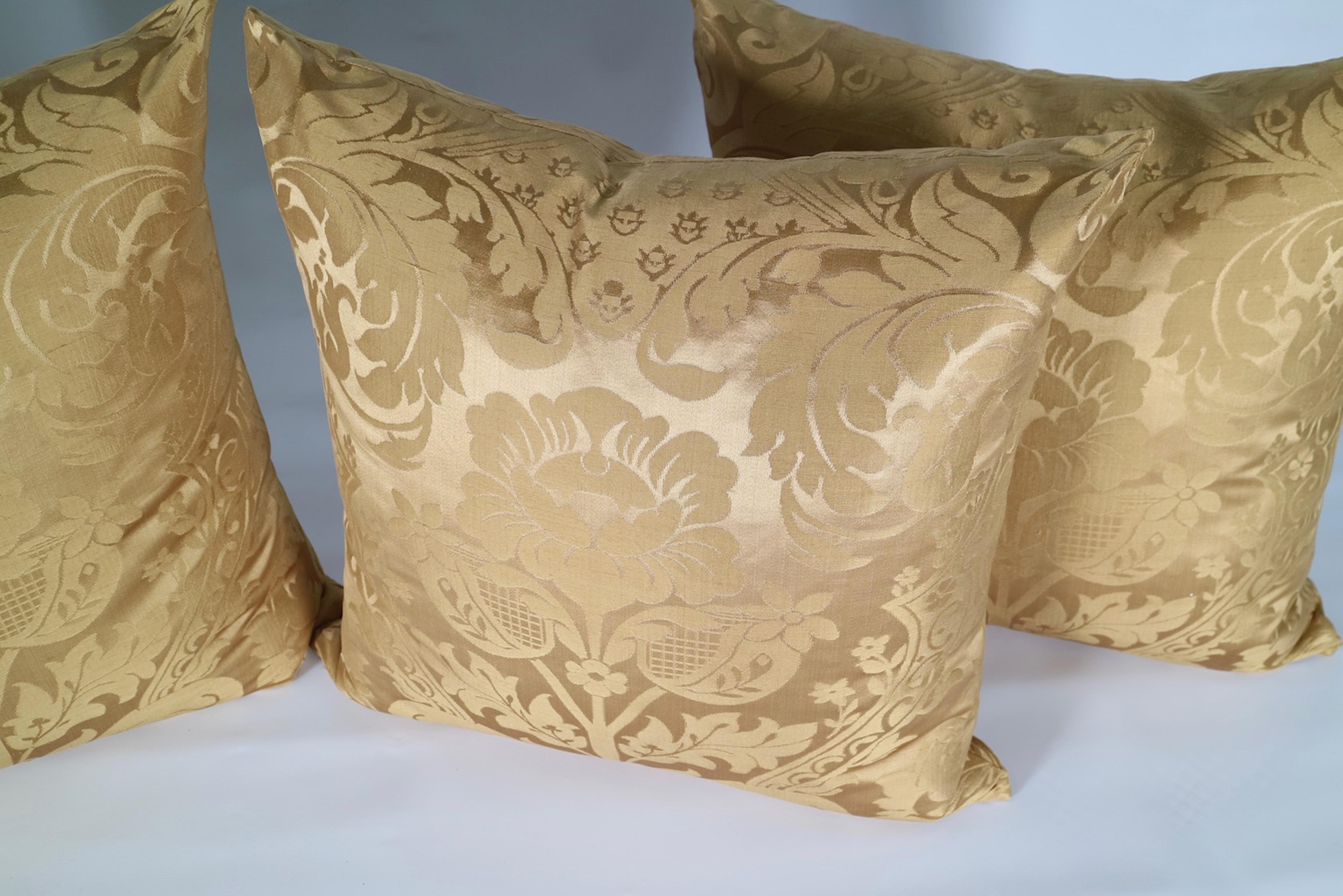 Antique square pillows in gold silk damask. The set includes new down and feather inserts. There are a total of four pillows with another set of four available. The pillows remain in excellent condition.